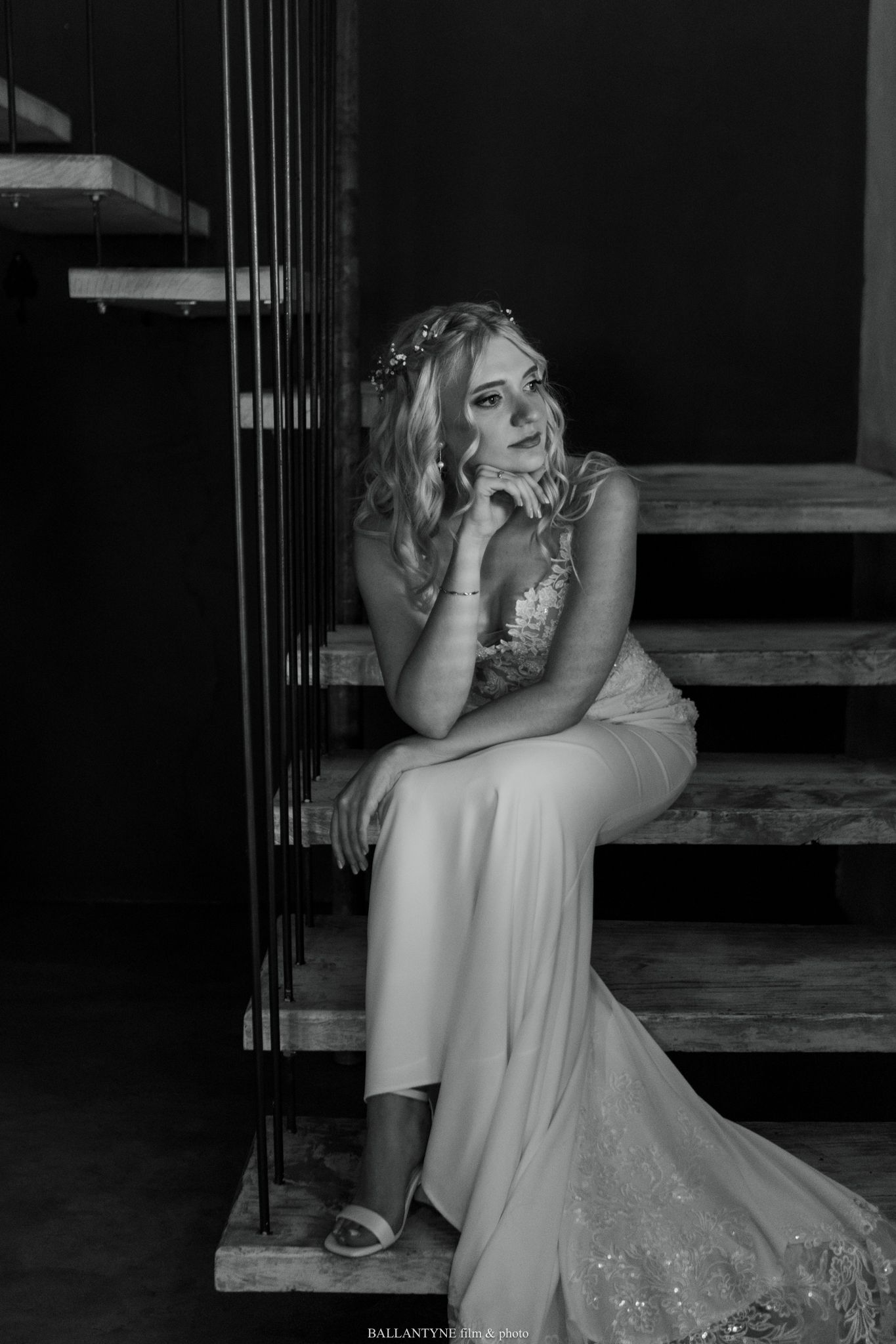 Emotional black and white portrait on staircase in flowing white dress.
