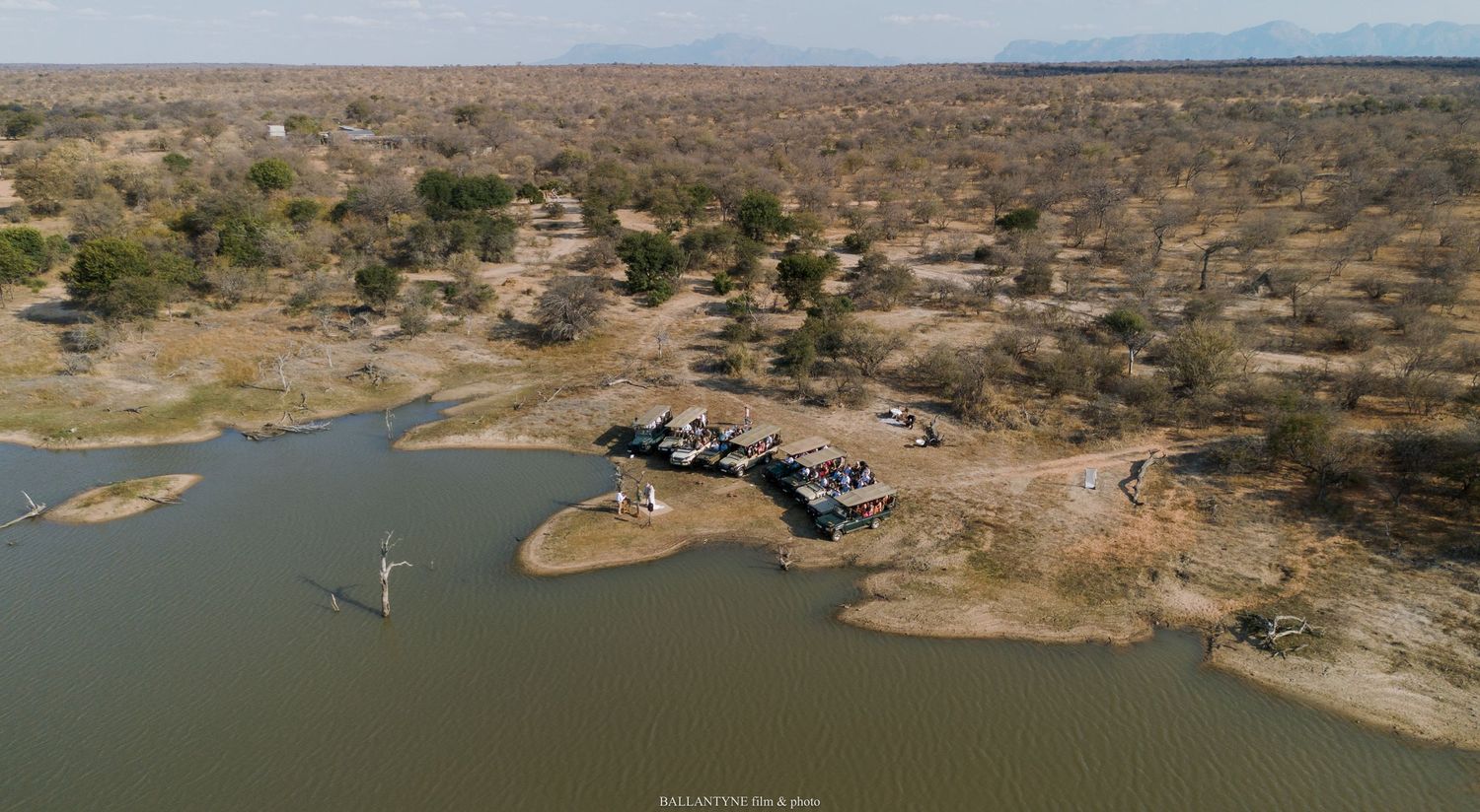 Aerial view of a waterfront venue surrounded by arid landscape and desert vegetation.