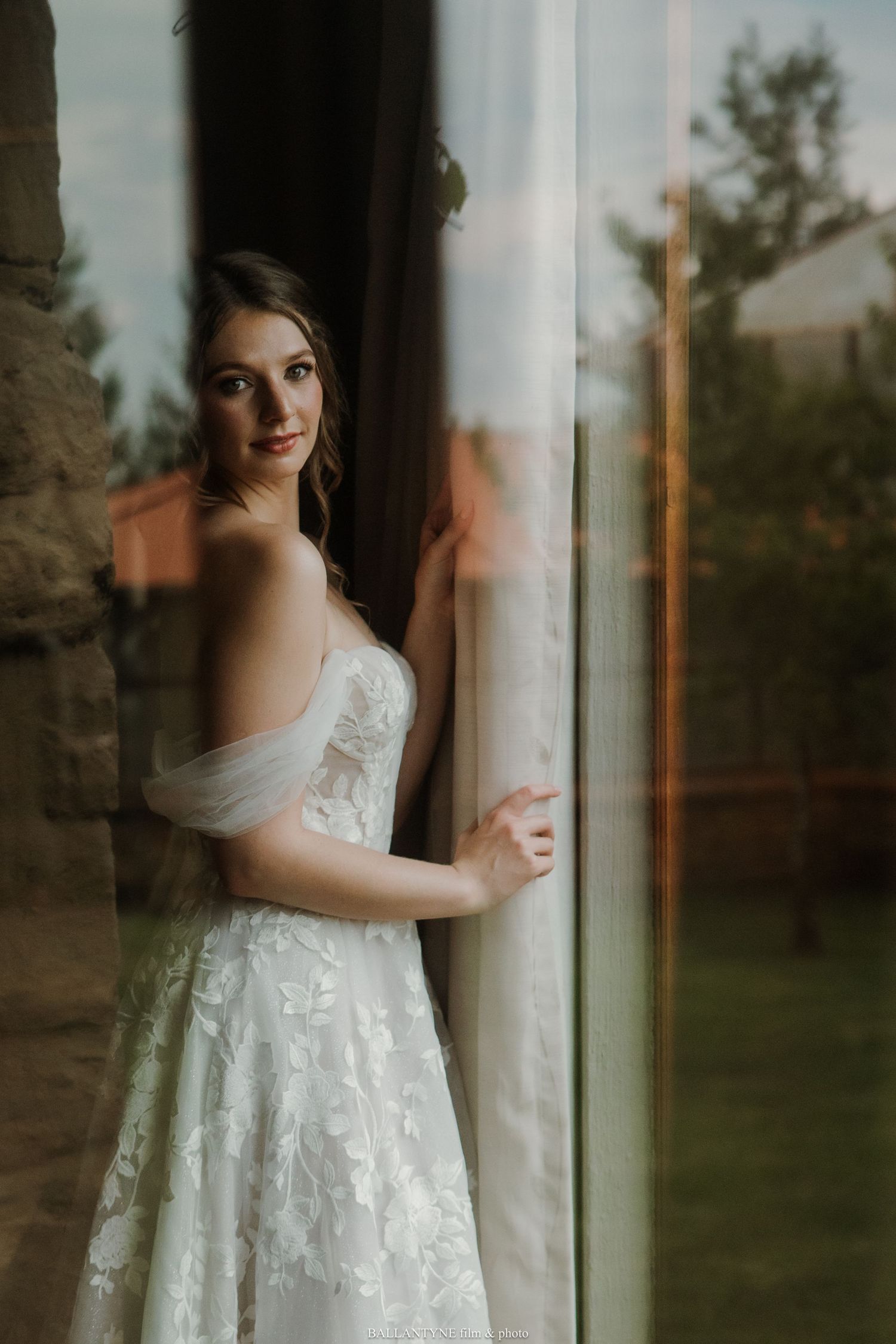 A soft natural light bridal portrait with a scenic outdoor backdrop.