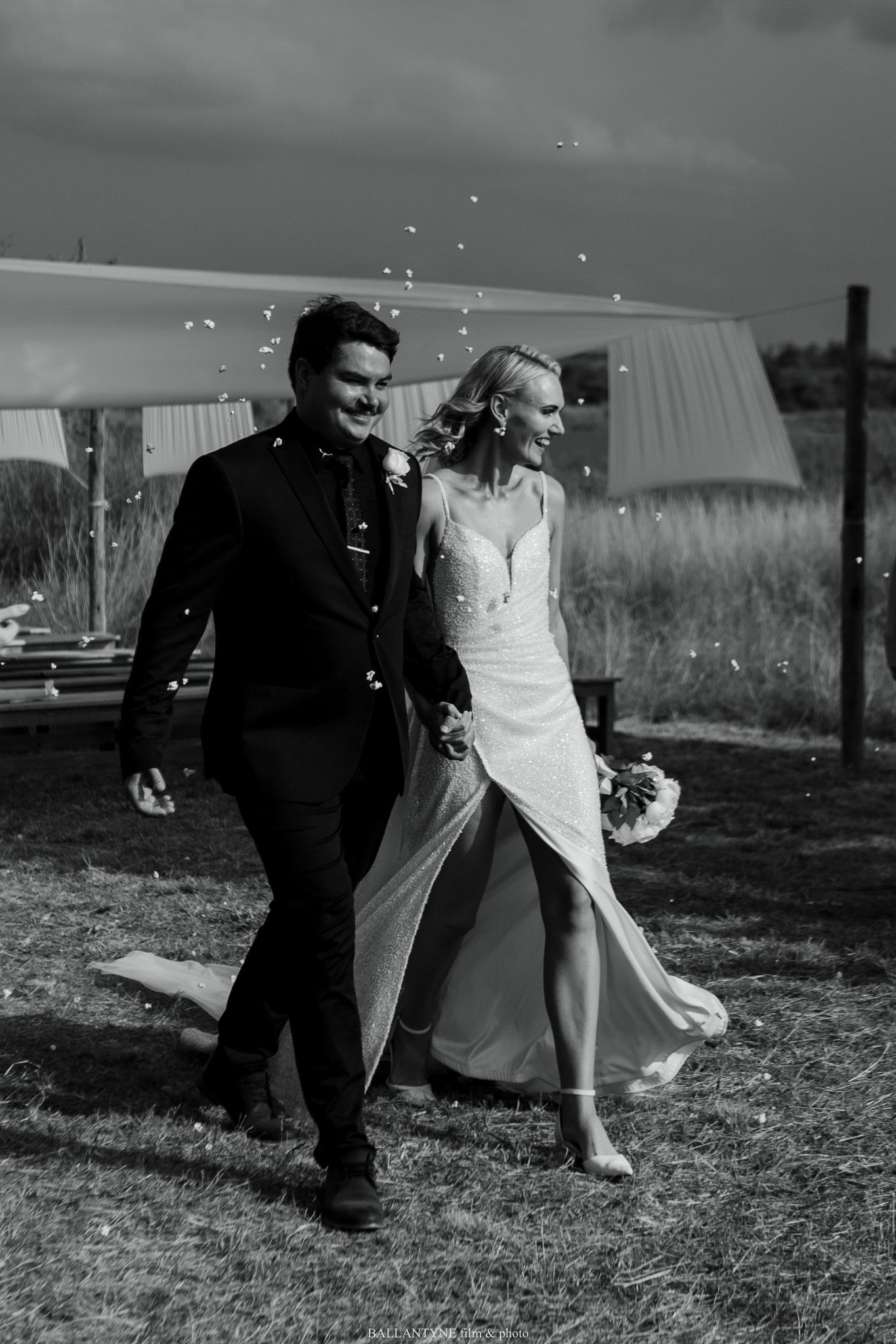 Black and white photo of a couple dancing in a grassy field.