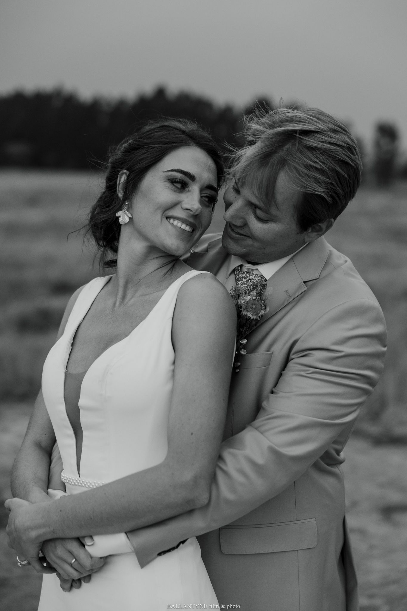 Romantic black and white portraits of a couple embracing in their wedding attire.