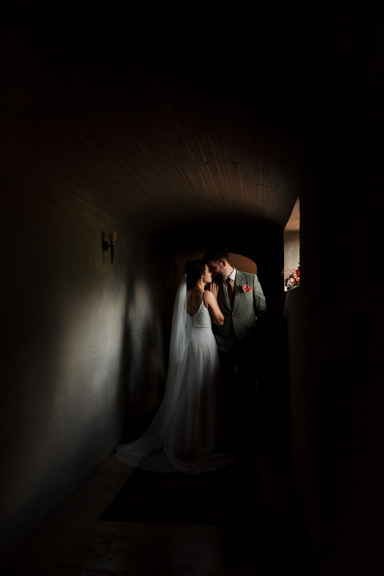 Moody corridor photograph with dramatic lighting and flowing fabric creating shadows.