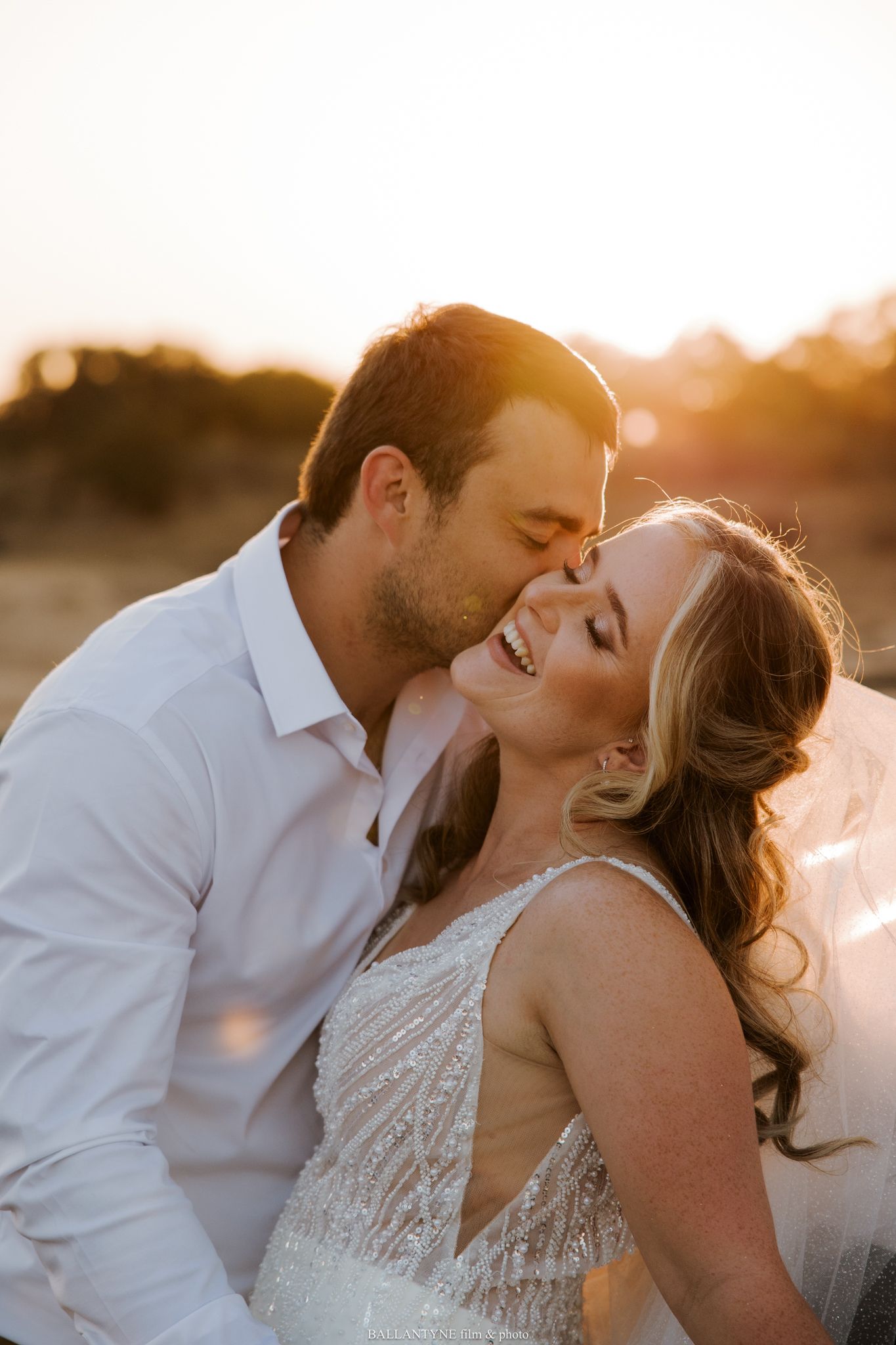 Romantic sunset wedding portrait with soft golden light.