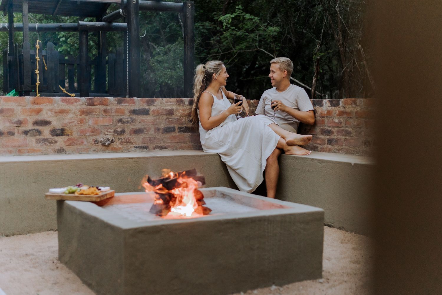 Couple enjoying an intimate dinner at a modern restaurant with glowing fire pit table centerpiece.