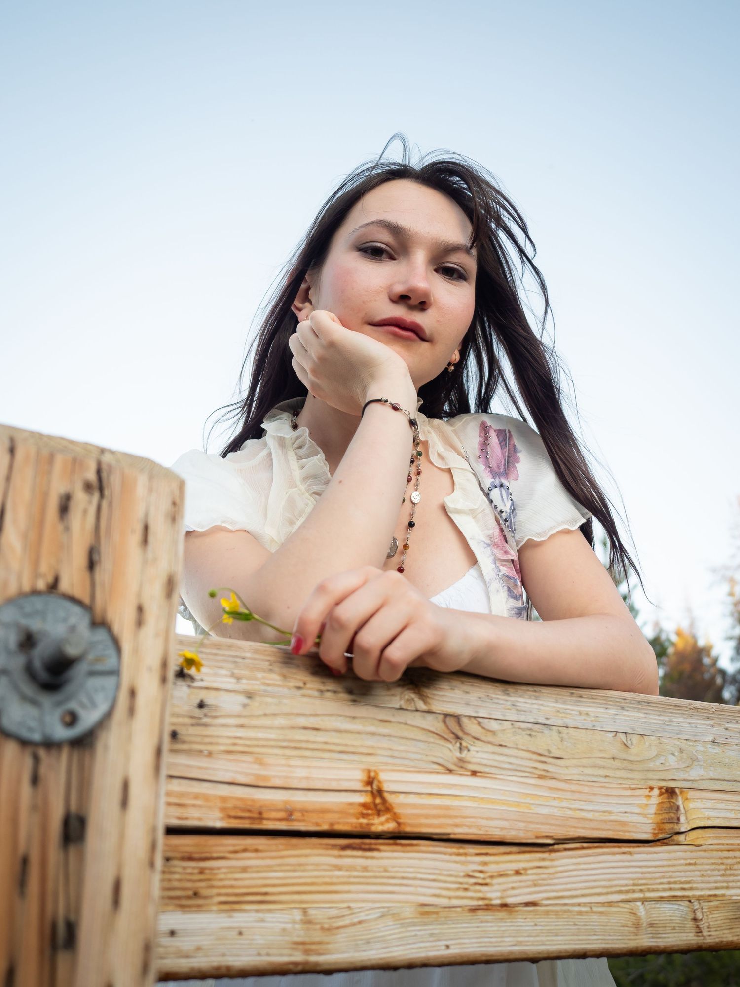 Portrait woman head in hand leaning on fence