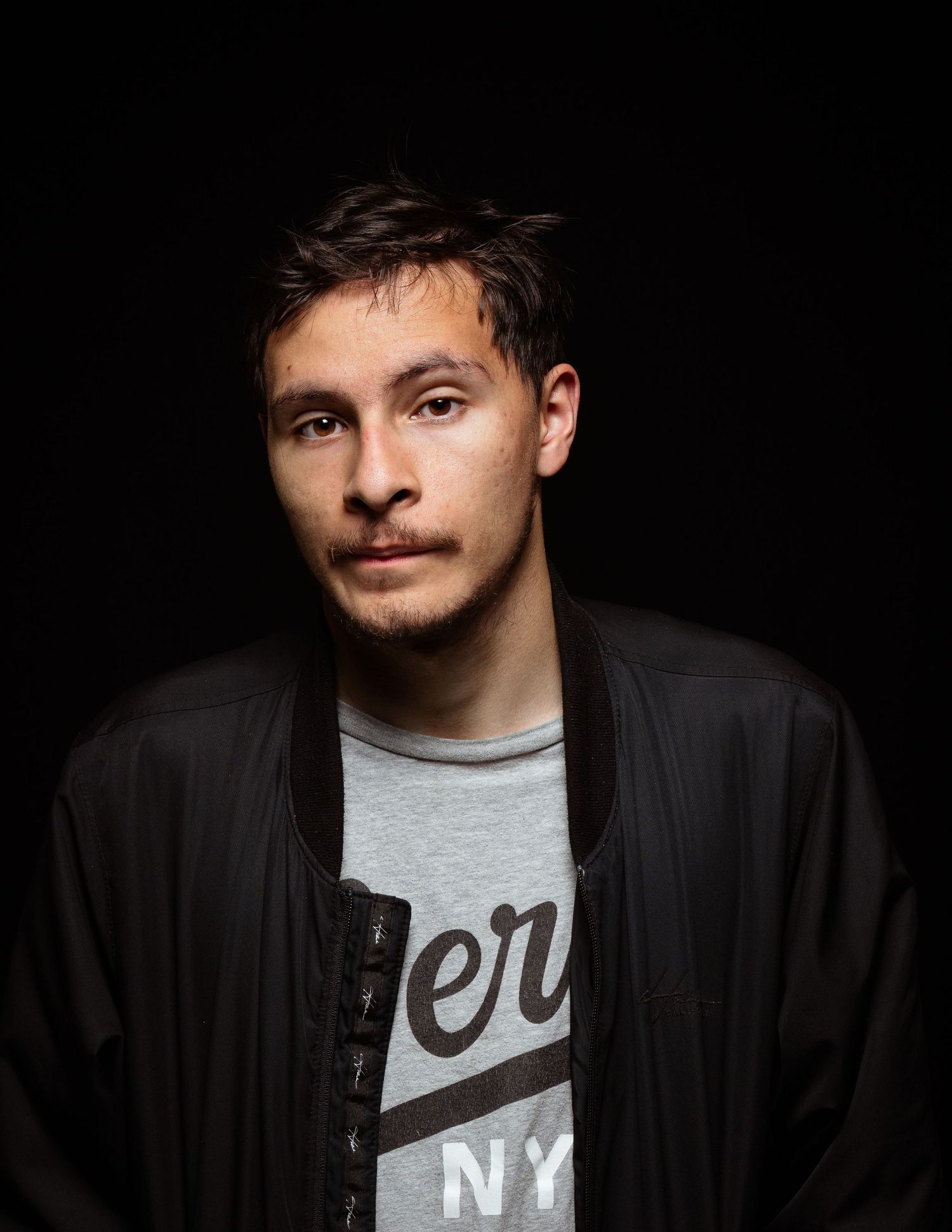 portrait black background grey shirt facing camera