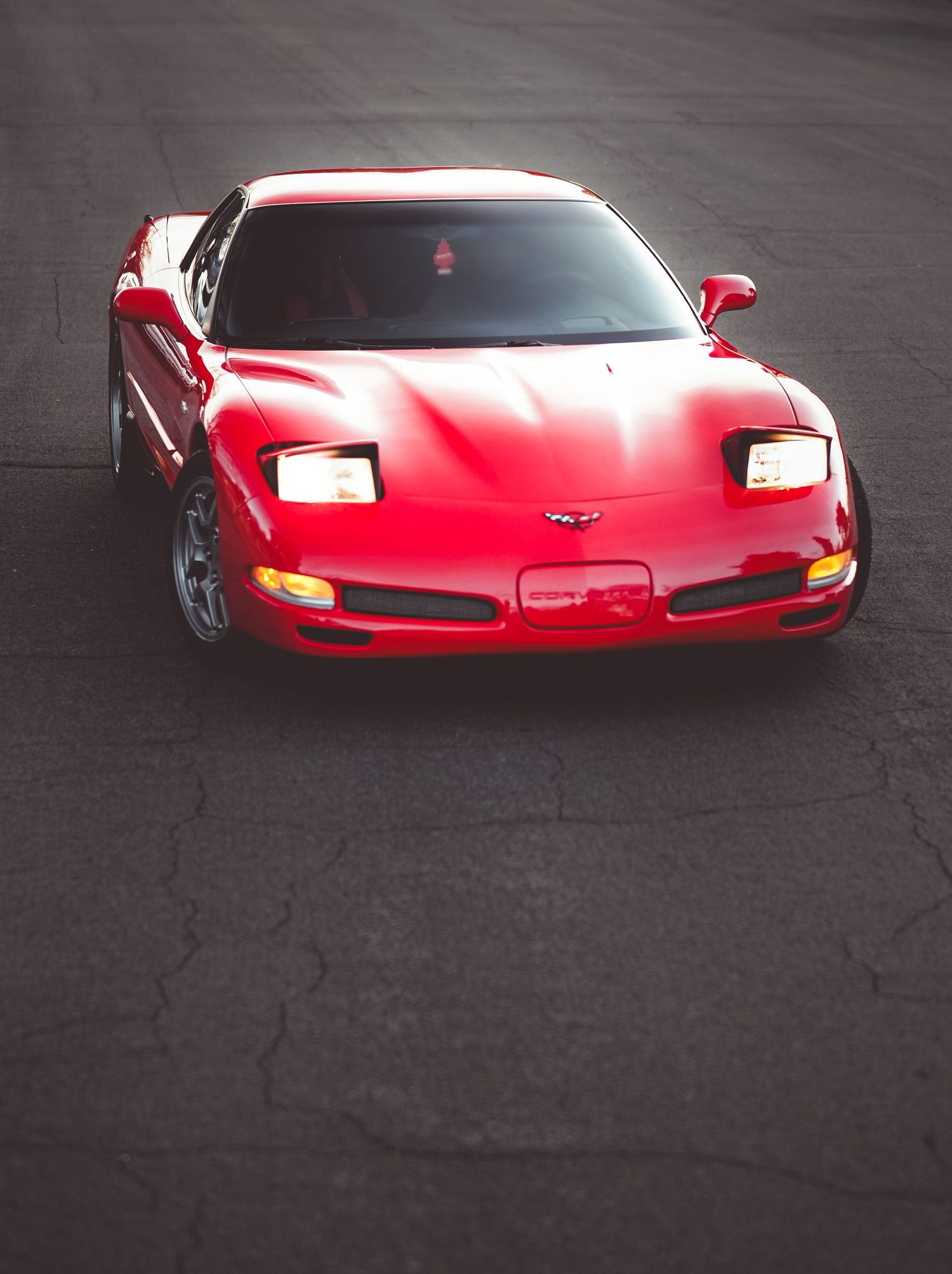 red corvette sports car portrait headlights on