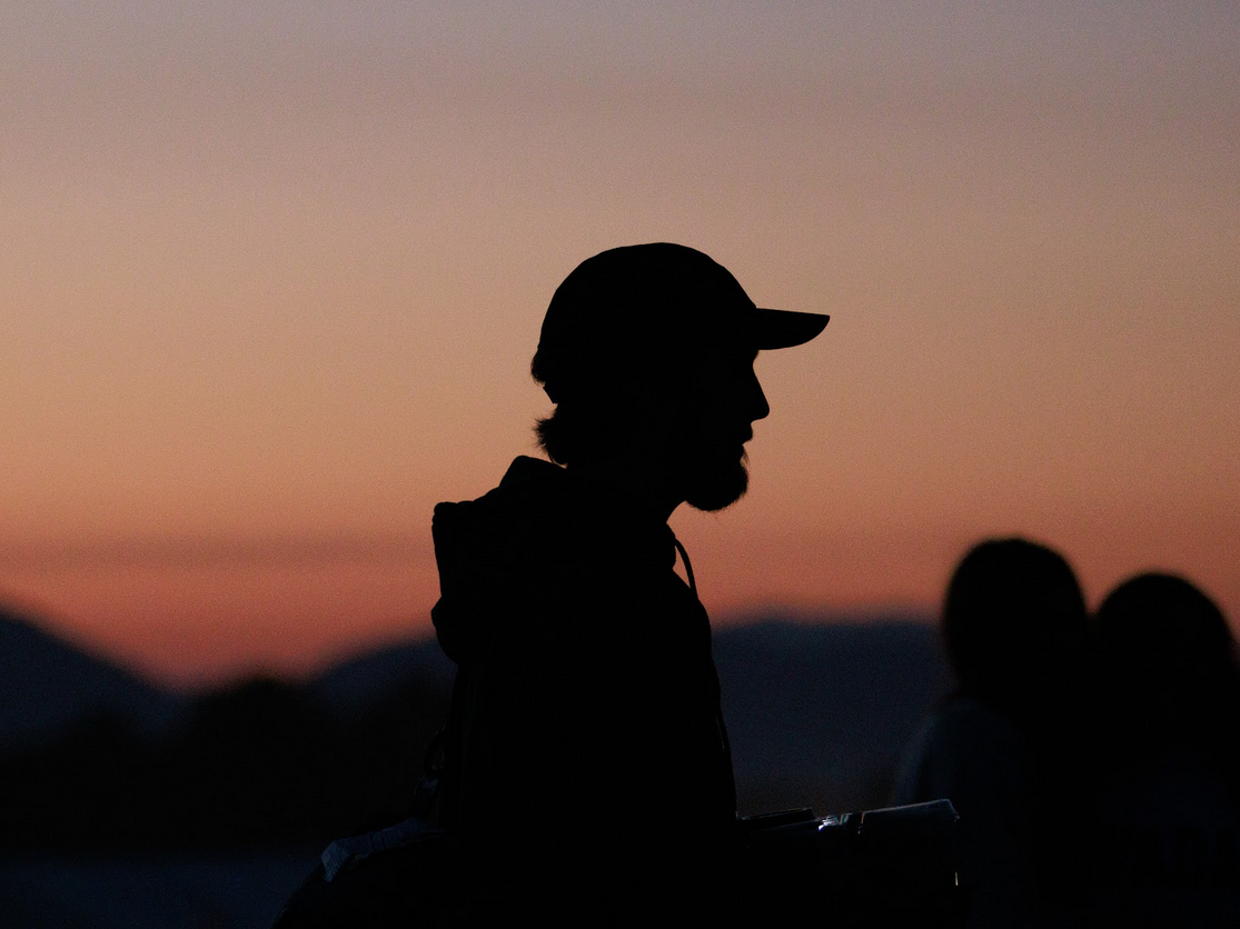 landscape early morning silhouette man in hat facing right sunrise background