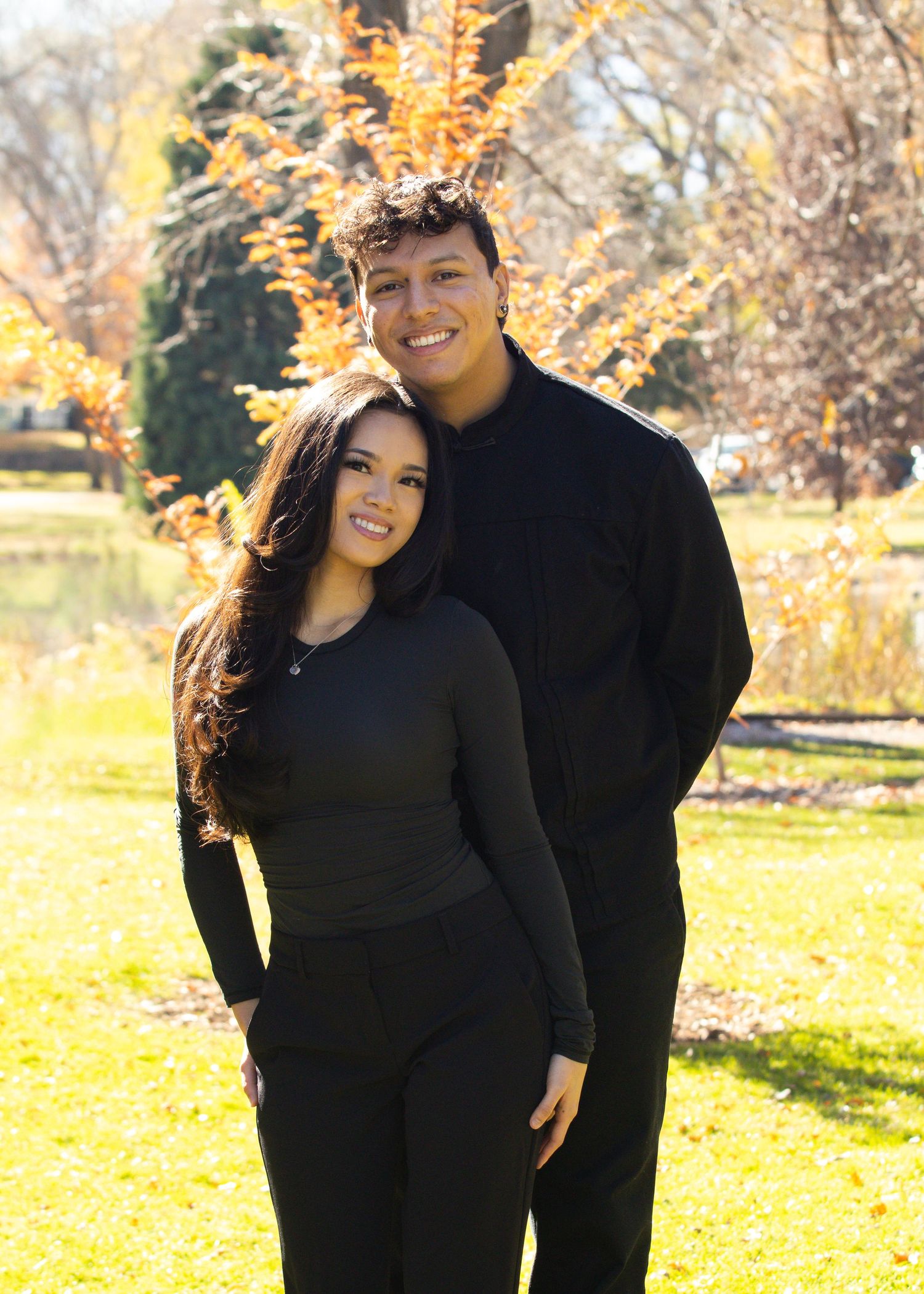 couple portrait arm around waist black outfits smiling standing