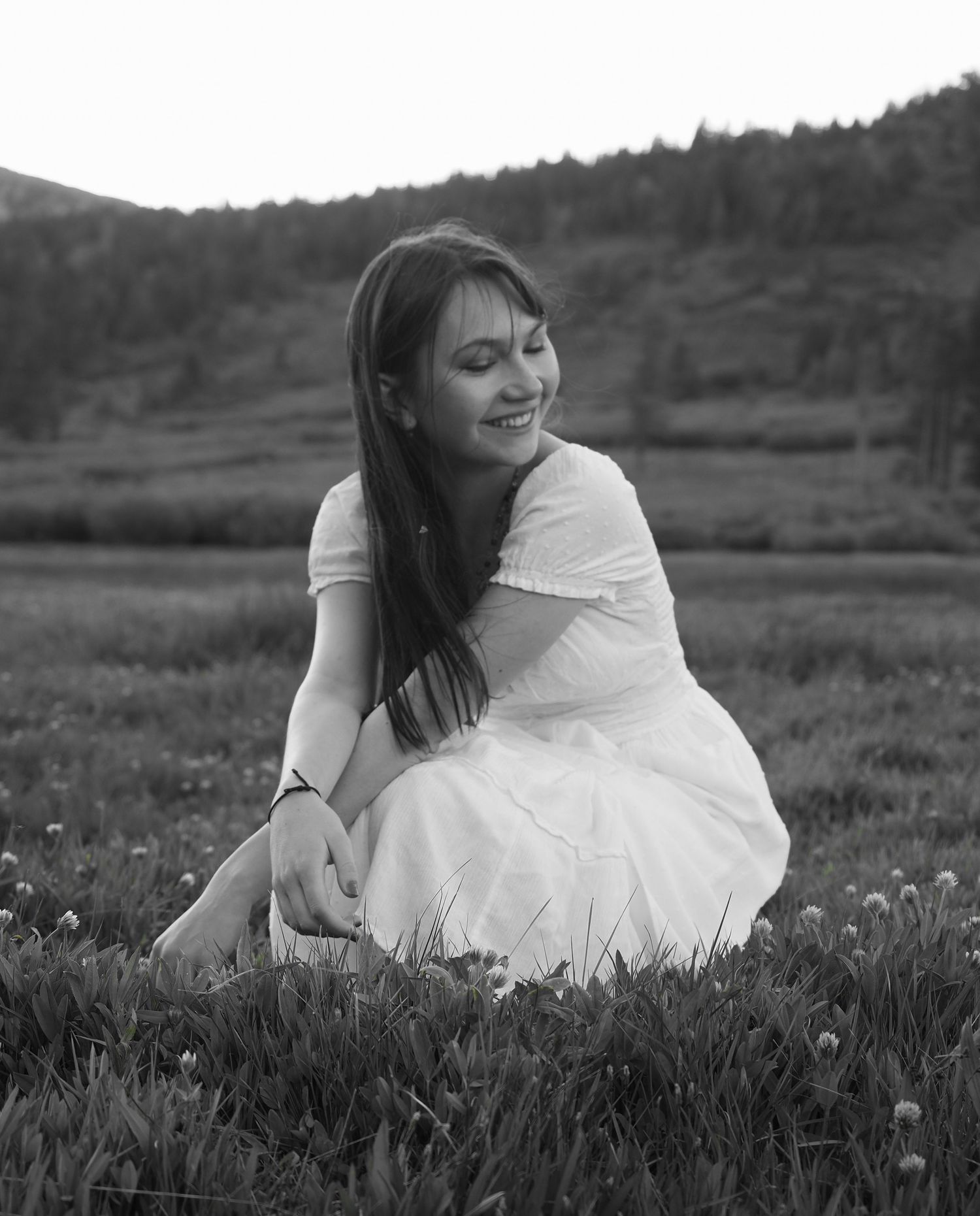 portrait black and white woman in dress smiling in field