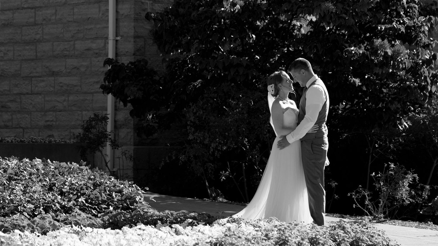 Black and white panoramic wedding sequence showing romantic moments and embraces.