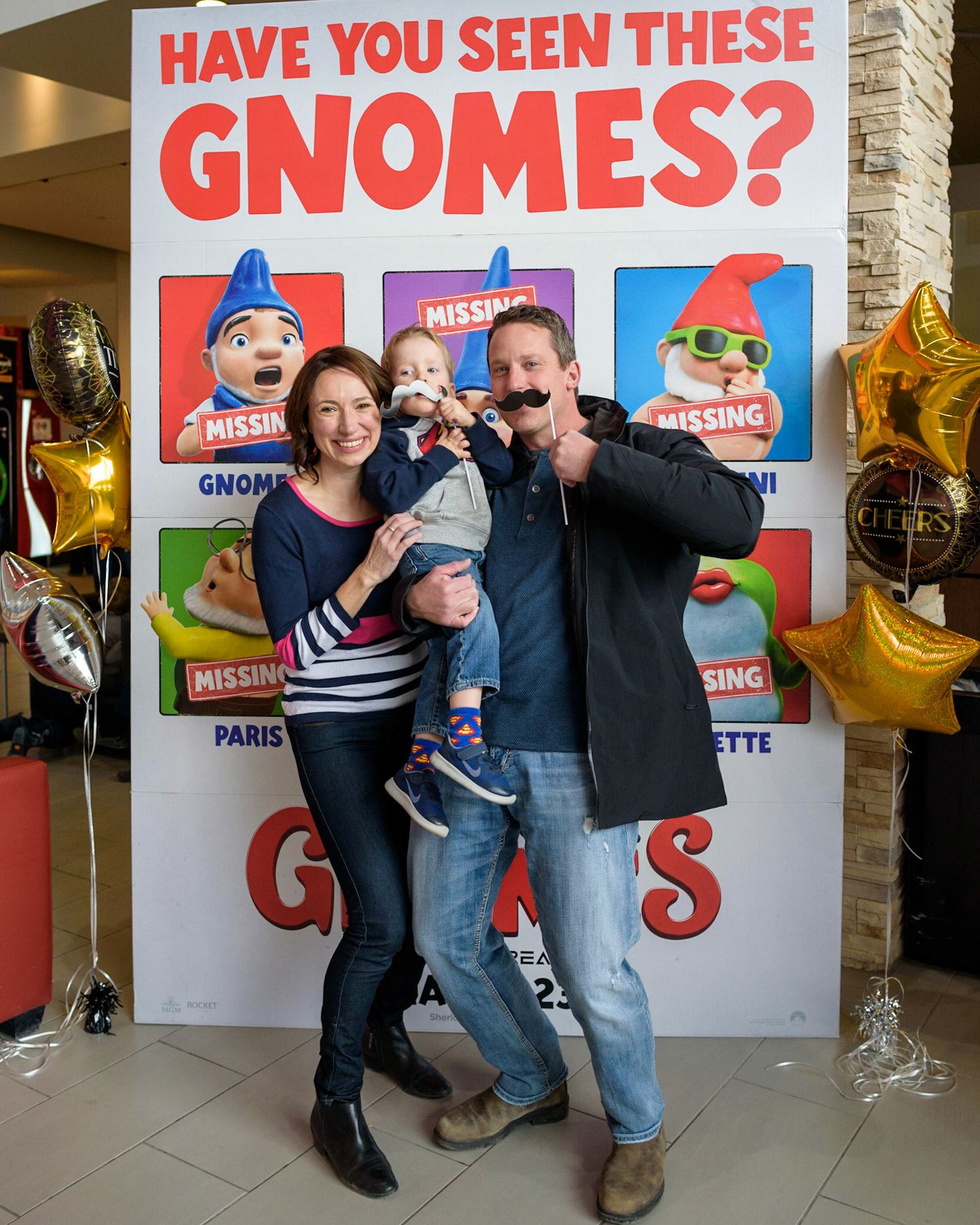 A series of photos showing people posing in front of a wall with red and white 'Have You Seen These Gnomes?' posters.