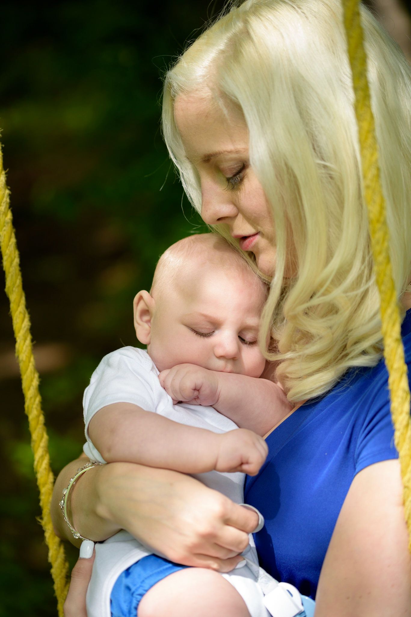 A tender moment showing a parent in blue embracing a small child in white.