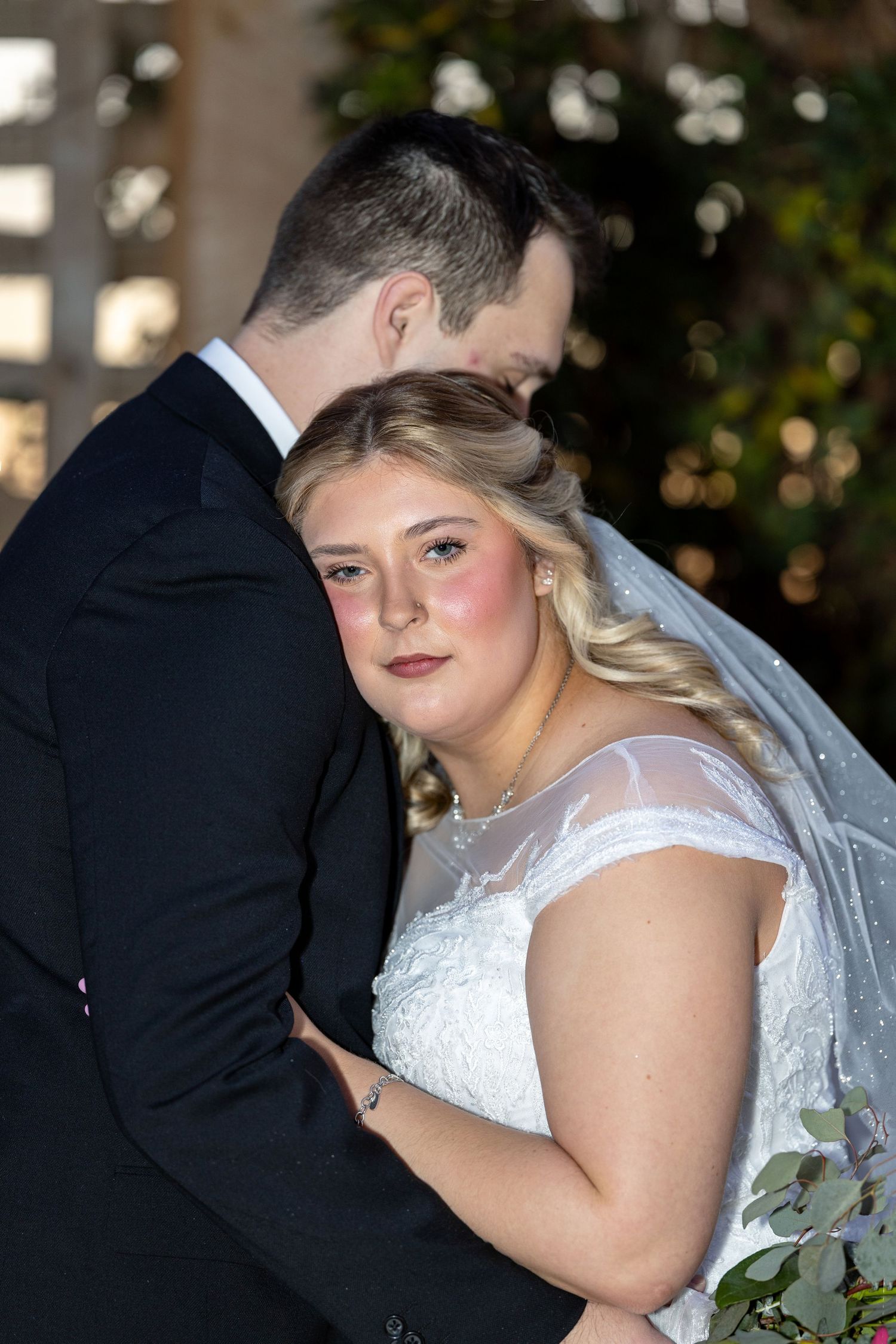 Intimate wedding portrait showing couple embracing during reception.