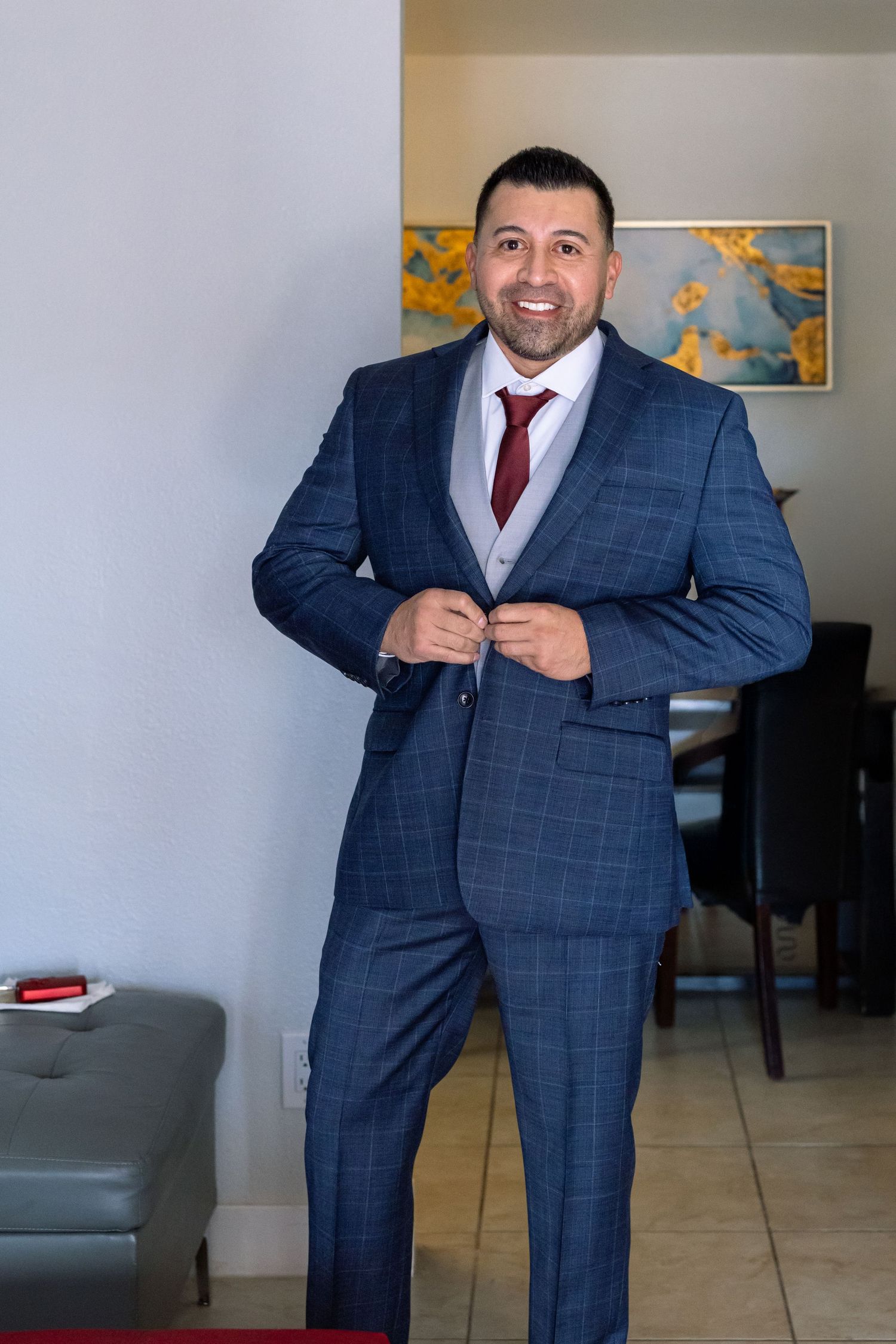 Person in a navy checkered suit preparing for formal event.
