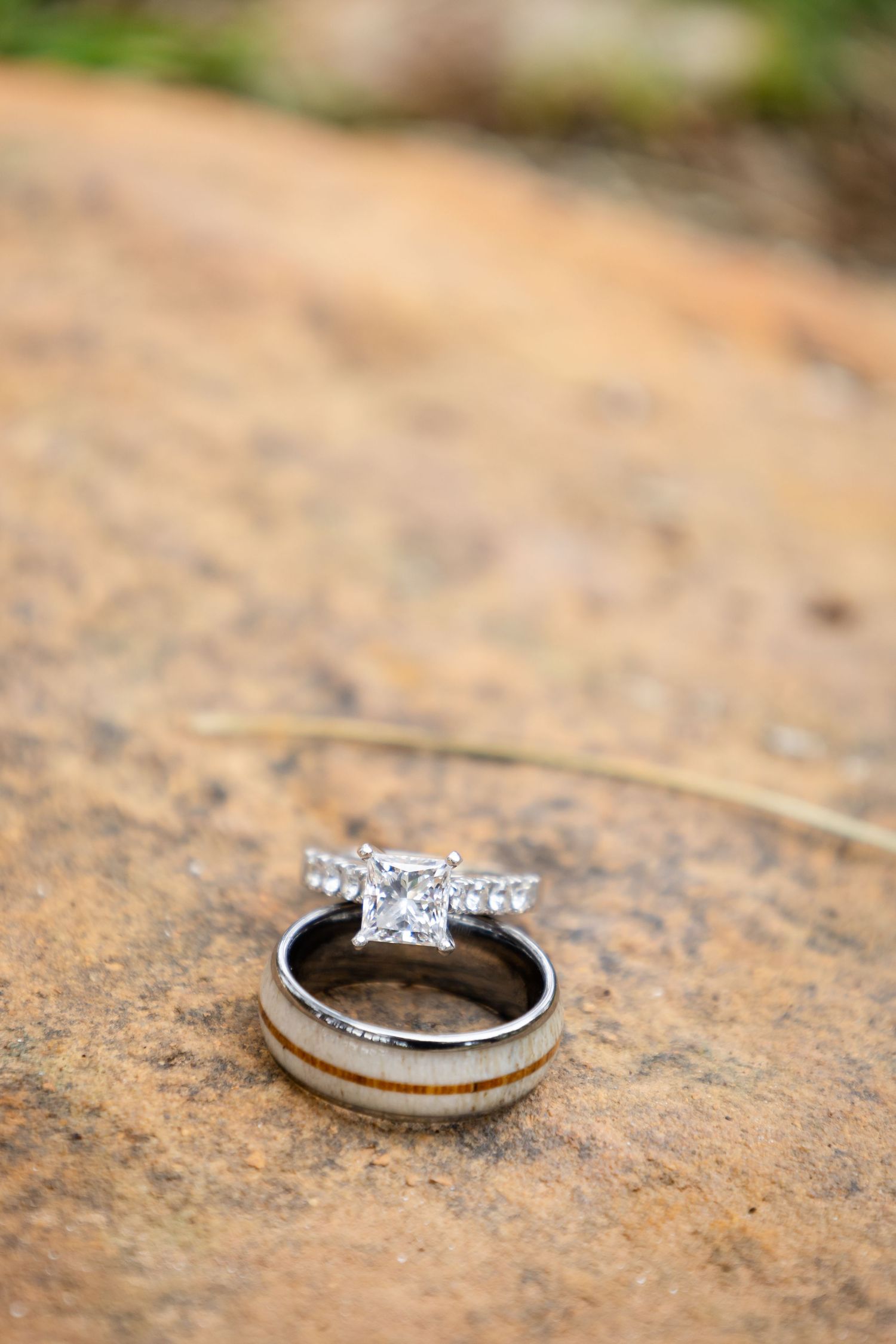 Wedding rings photographed in detail on a textured stone surface.