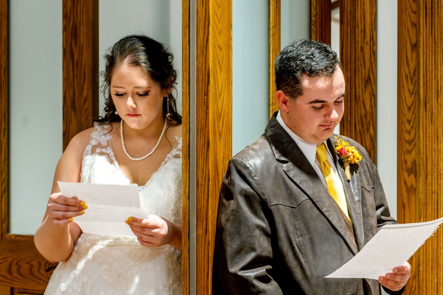 Wedding party members reading from papers during an emotional ceremony moment.