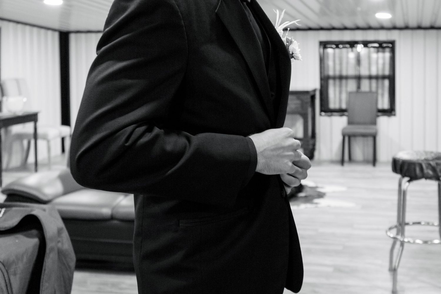 Black and white image showing formal wedding attire details.