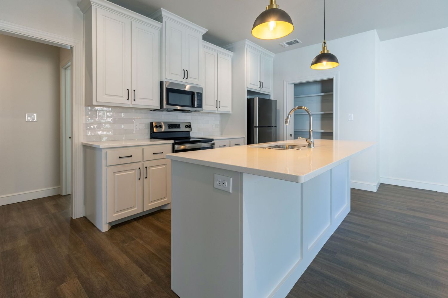 Modern white kitchen interior with pendant lighting and sleek cabinetry shown from multiple angles.