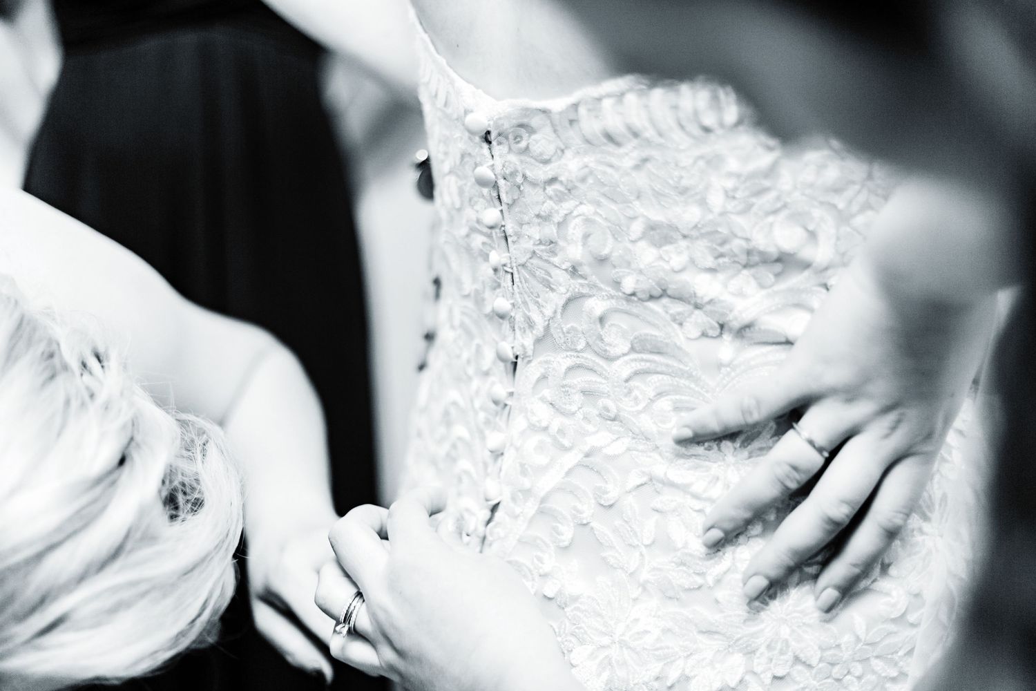 Detail shot of intricate lace wedding dress buttons and corset back.