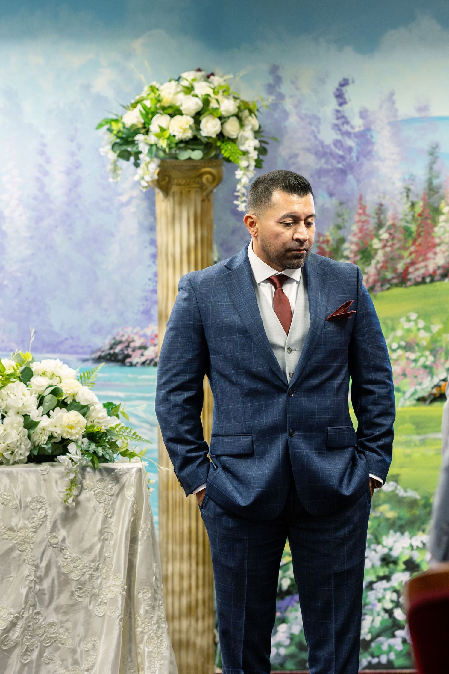 Elegant wedding portrait setup with classical columns and floral arrangements.