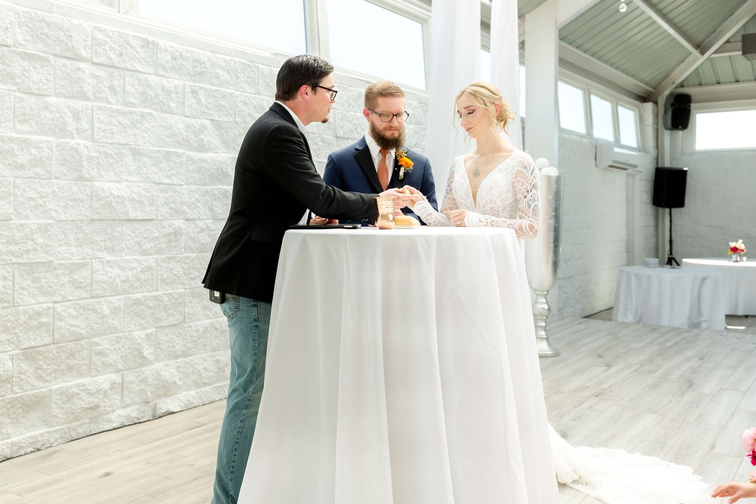 Modern white wedding venue with minimalist decor and round reception tables.