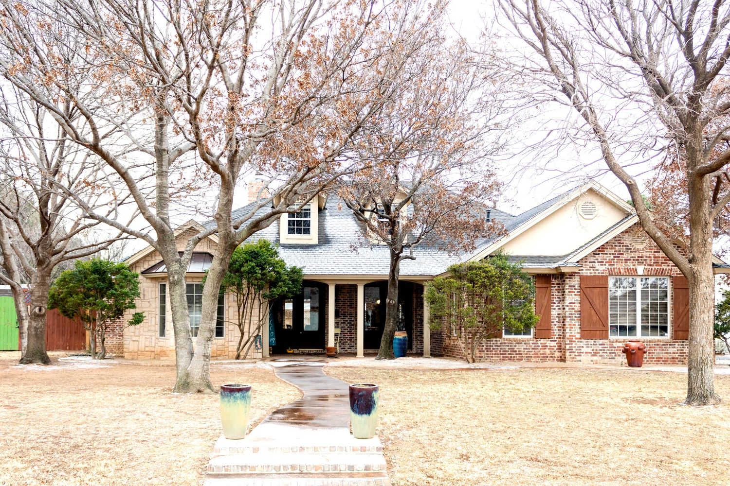Wide landscape view of suburban homes with dormant trees in early spring.