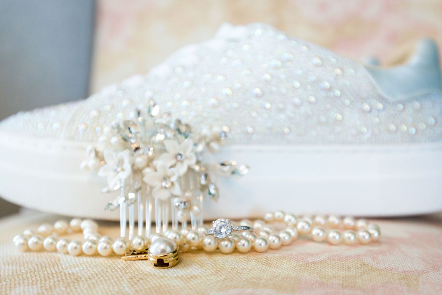 Close-up of shimmering bridal accessories with pearls and crystals on soft background.