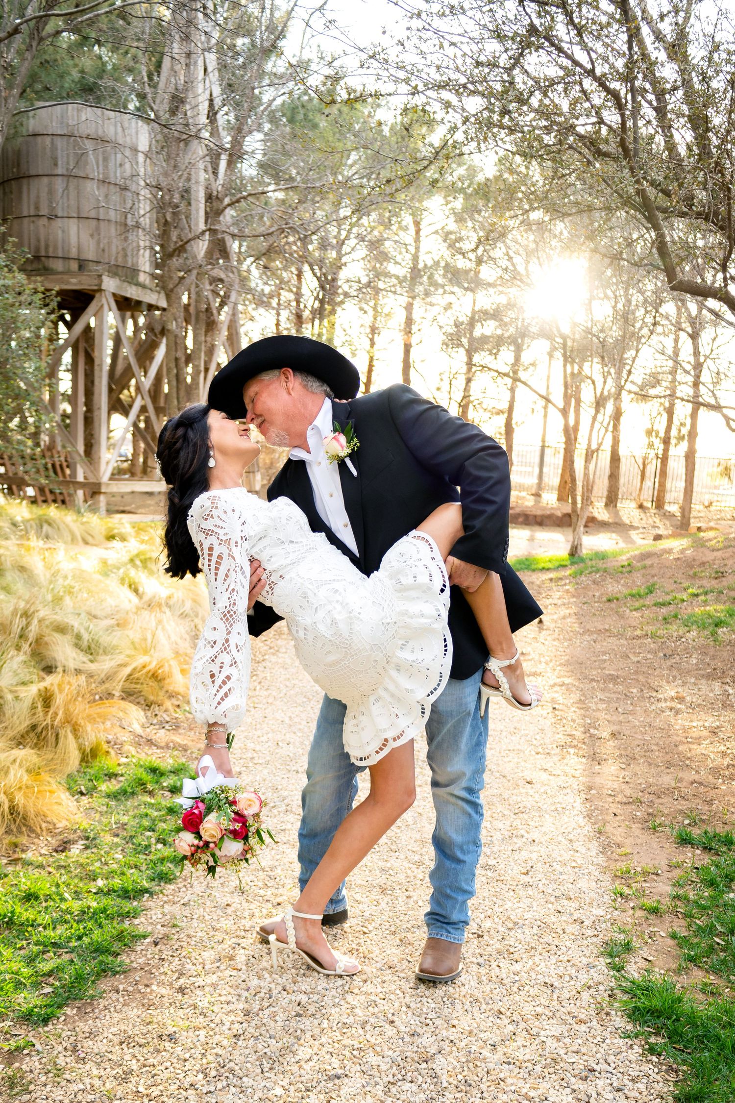 Playful wedding couple photos on a tree-lined path during golden hour.