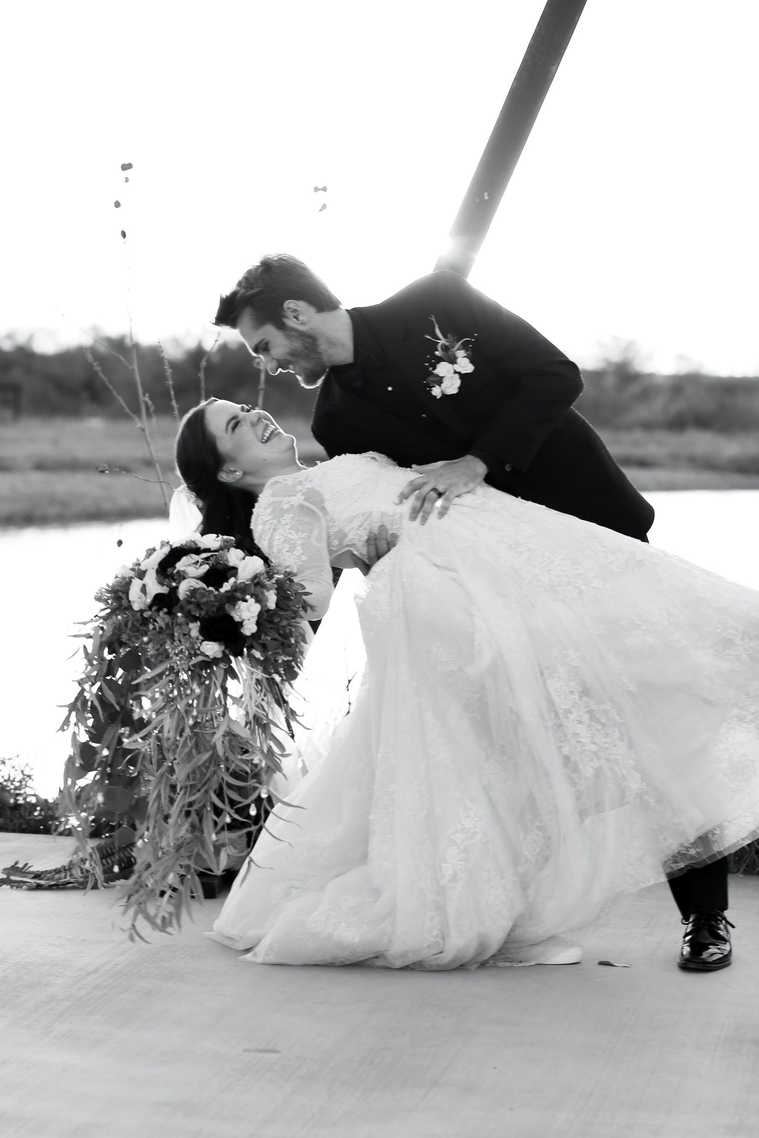 Romantic black and white wedding photos showing couple in intimate poses on the ground.
