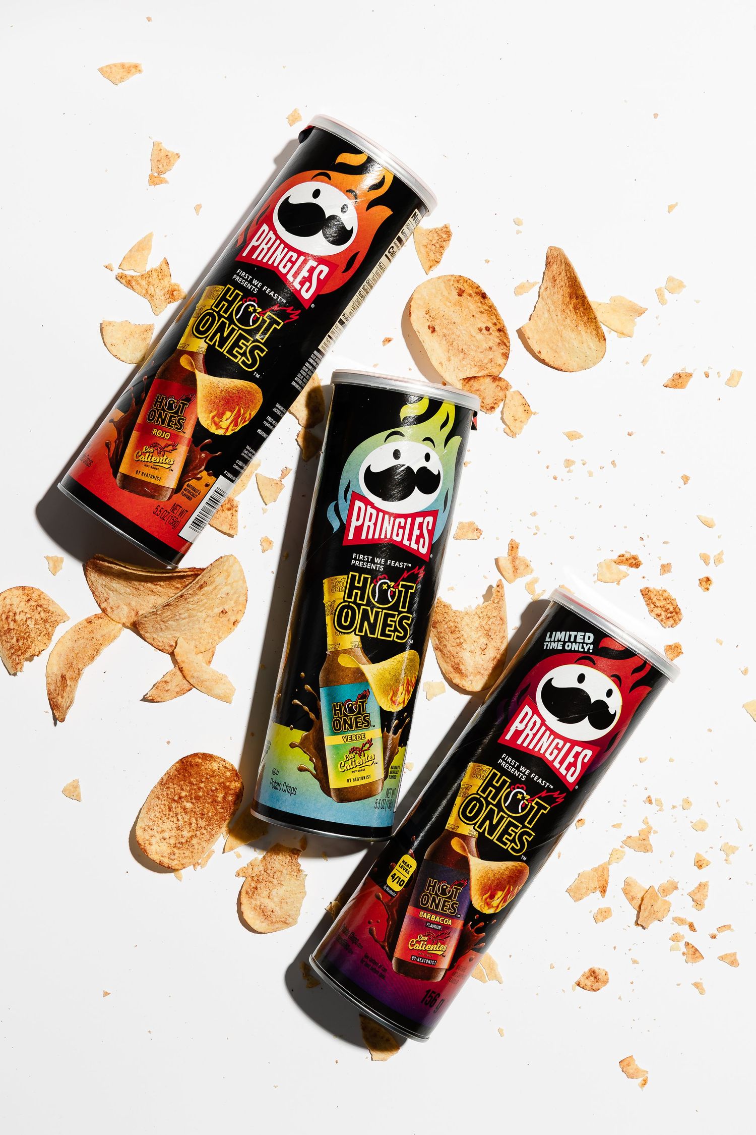 Colorful beverage cans with artistic designs scattered on white background.