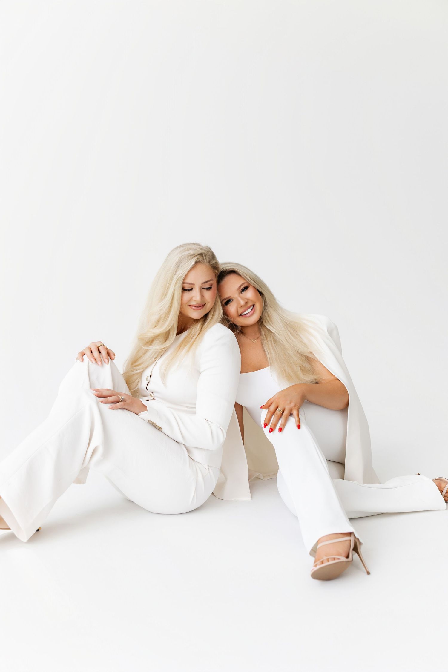 Creative white-themed studio photoshoot with playful poses against white background.
