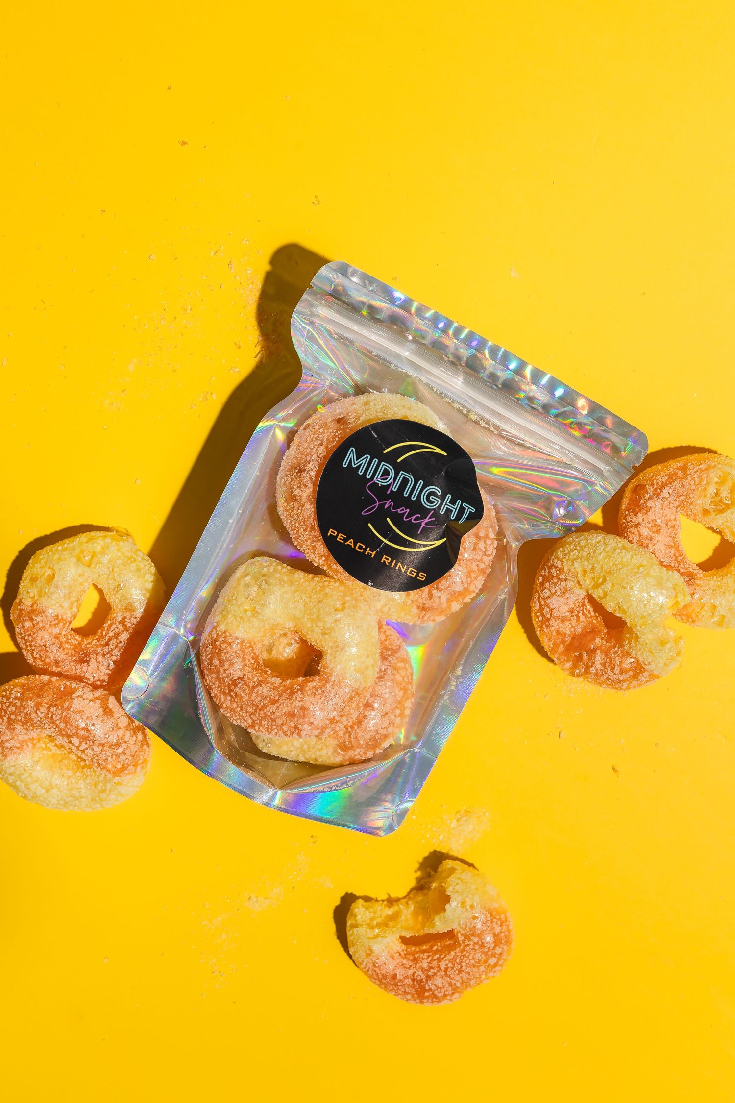 Orange-dusted snacks arranged in a line against a bright yellow background.
