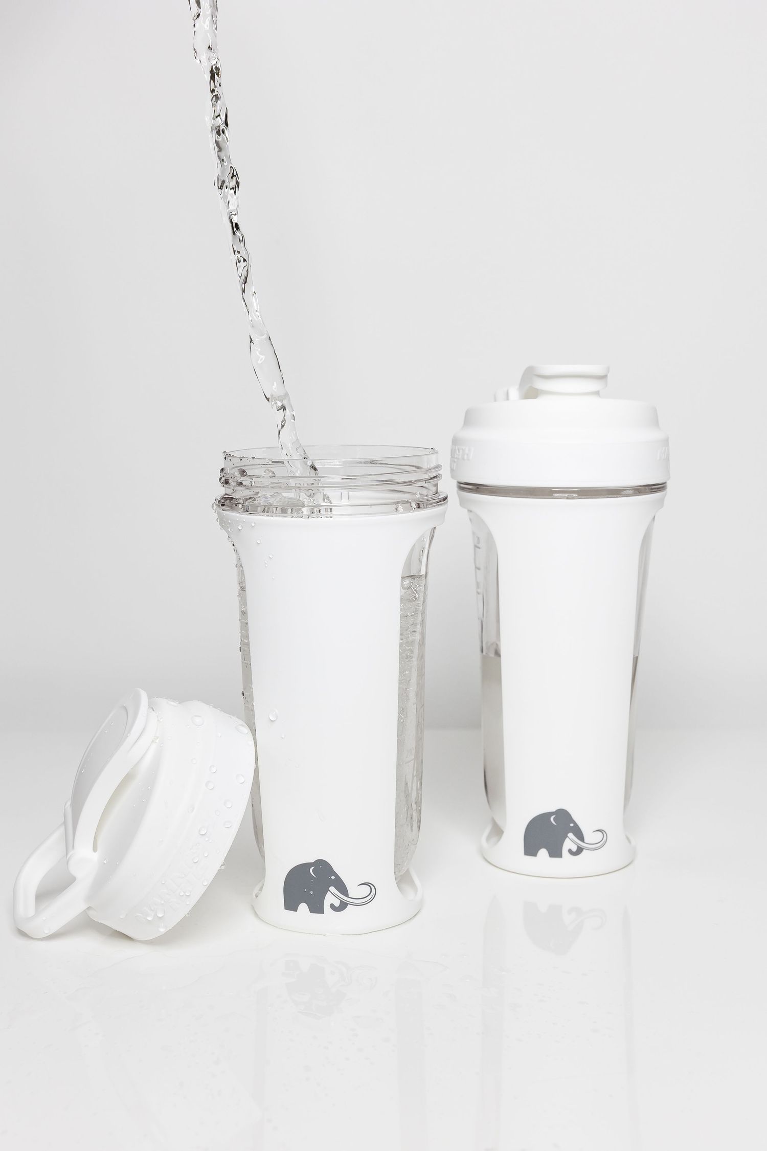 Collection of white ceramic containers with elephant logo arranged in progressive sequence.