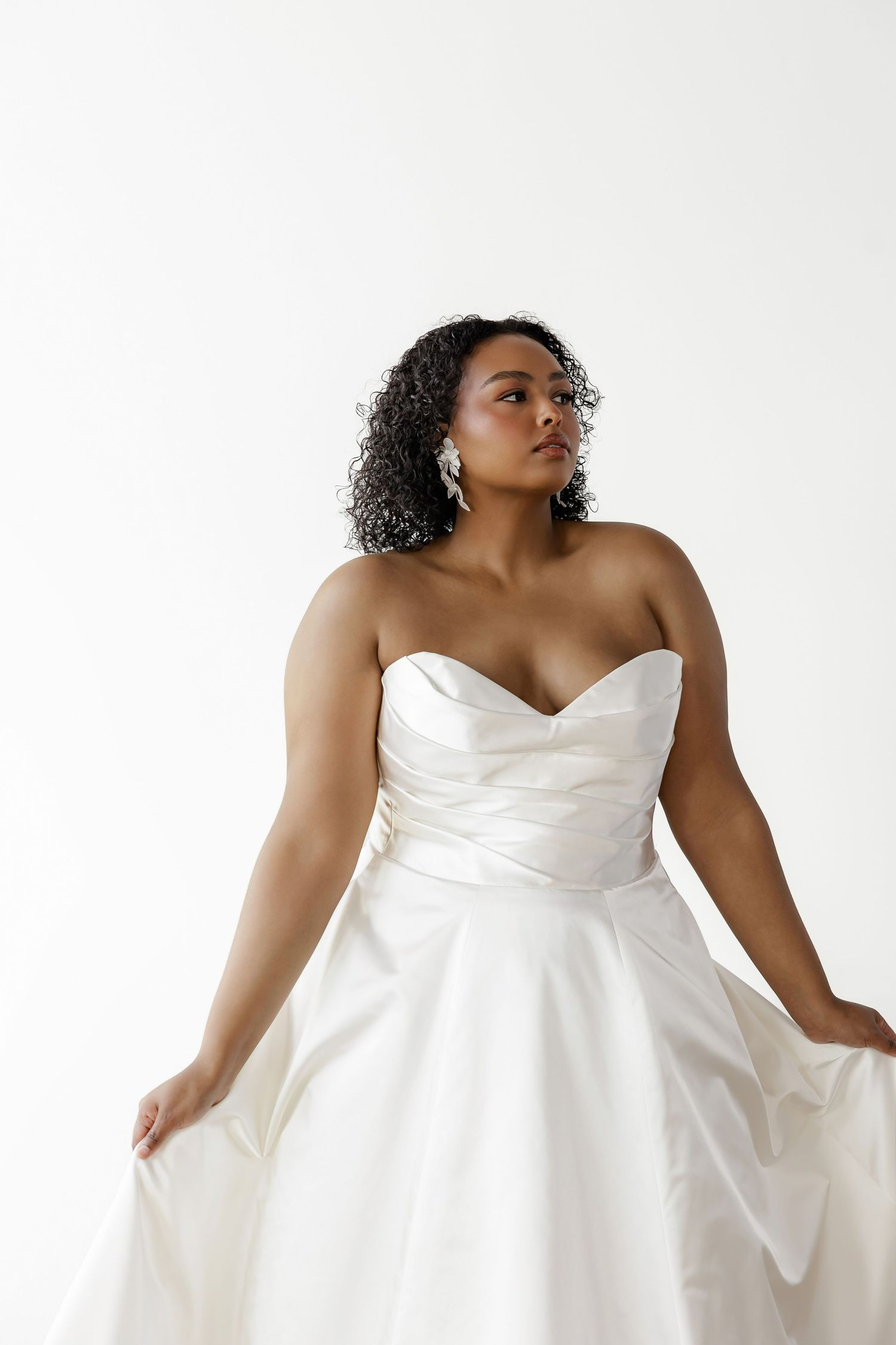 Strapless white wedding gown with sweetheart neckline and full skirt shown in dynamic poses.
