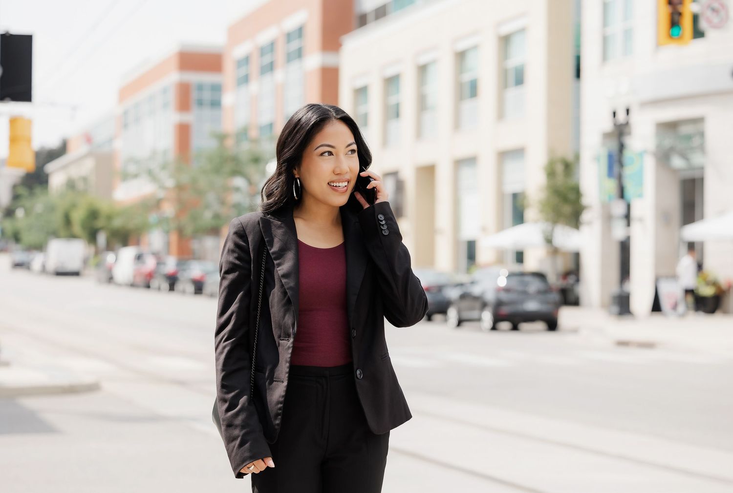 Business professional walking on an urban sidewalk while talking on a mobile phone.