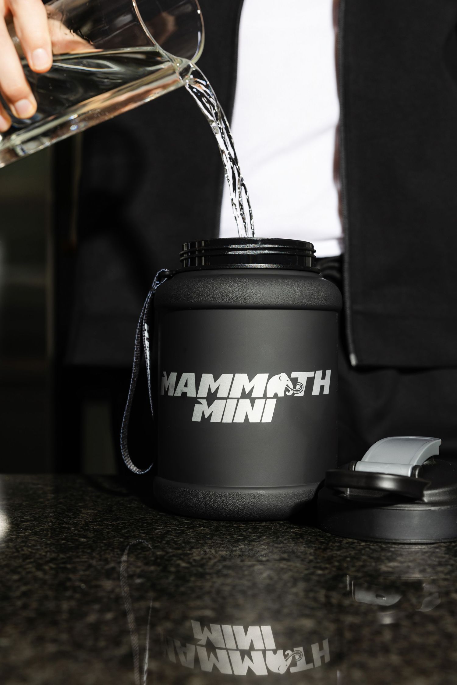 Close-up of black water bottle with Mammoth Mini branding on dark surface.