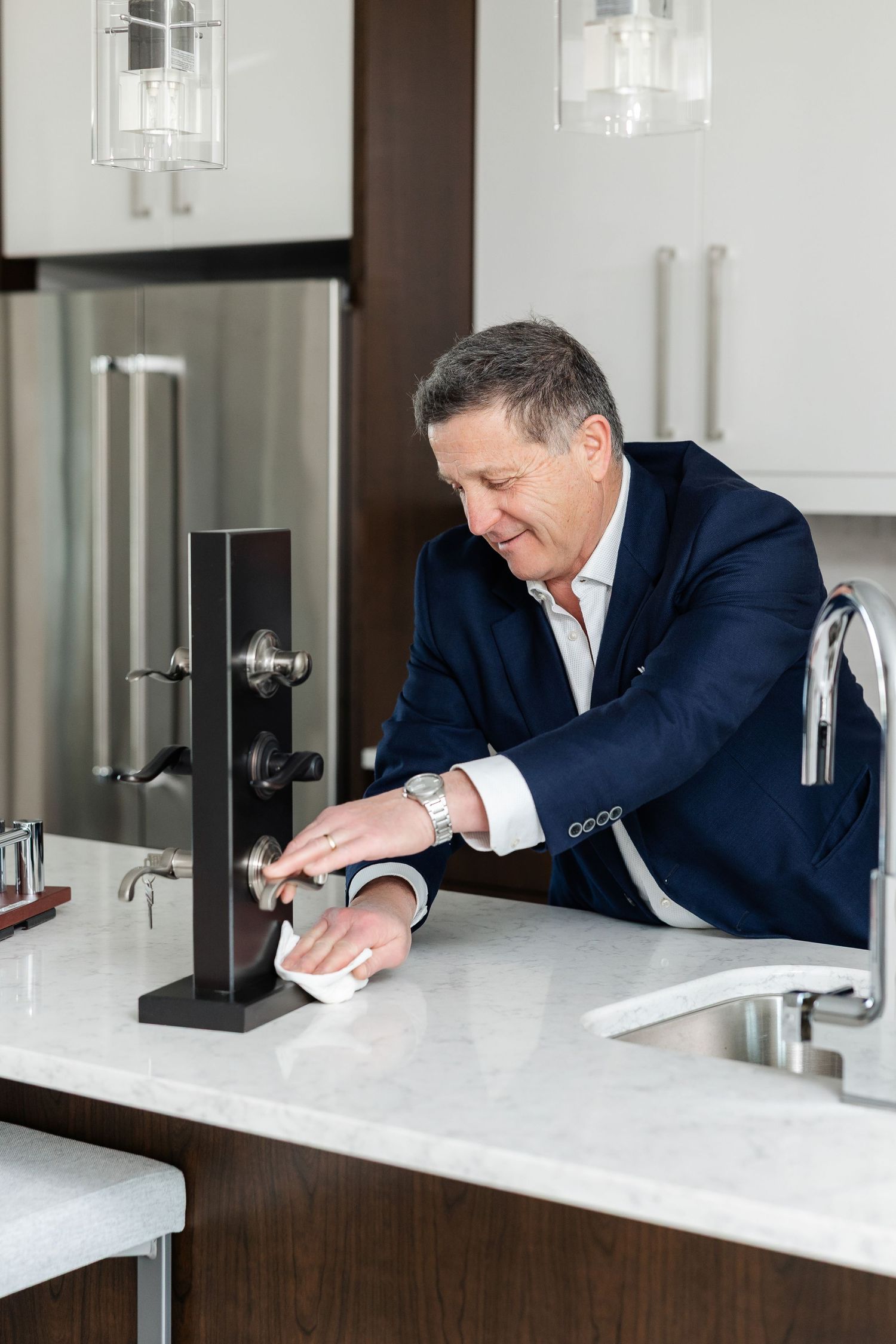 Professional inspecting white marble countertop surface in luxury kitchen.