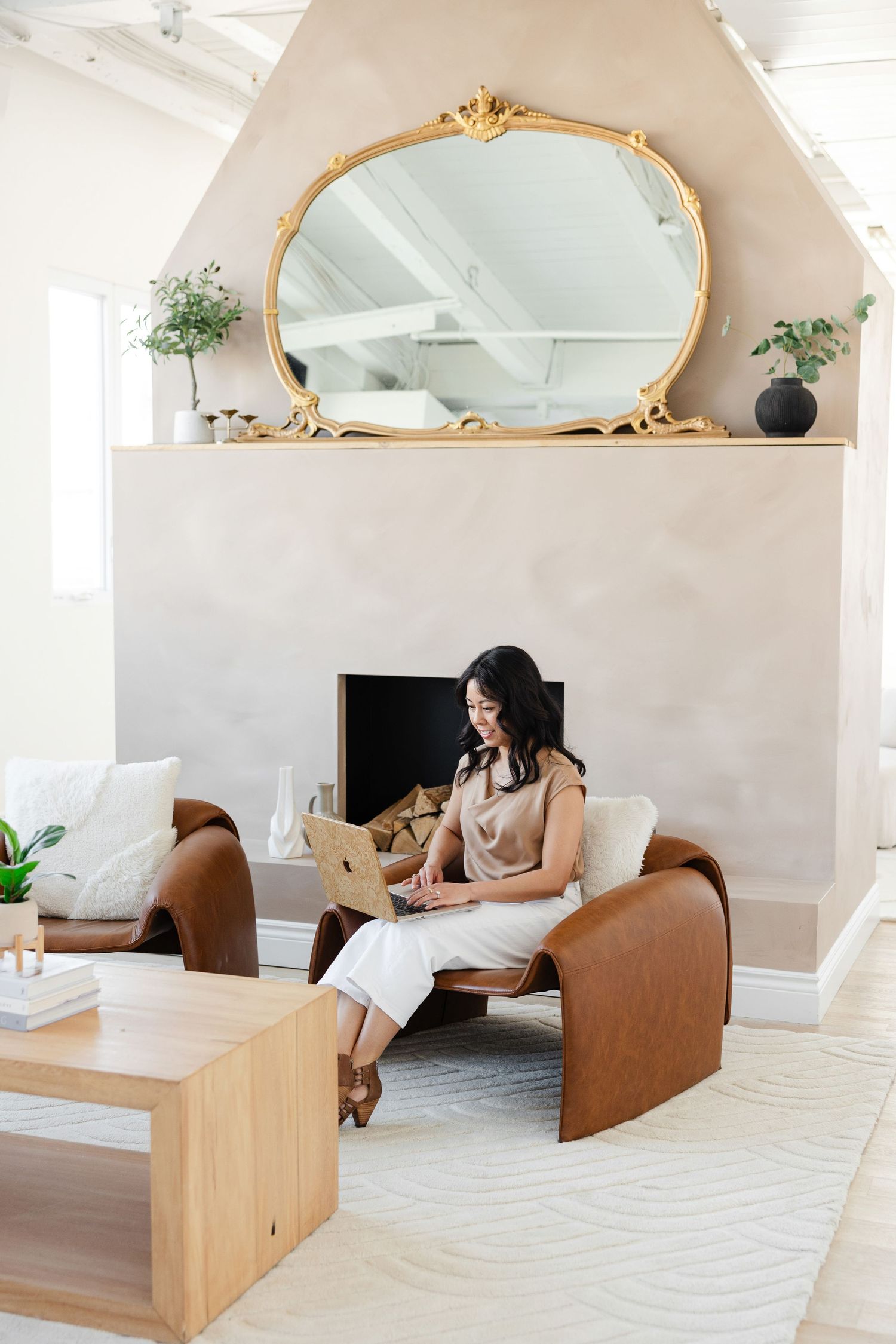 Elegant office space with ornate gold mirror and wooden furniture against neutral walls.