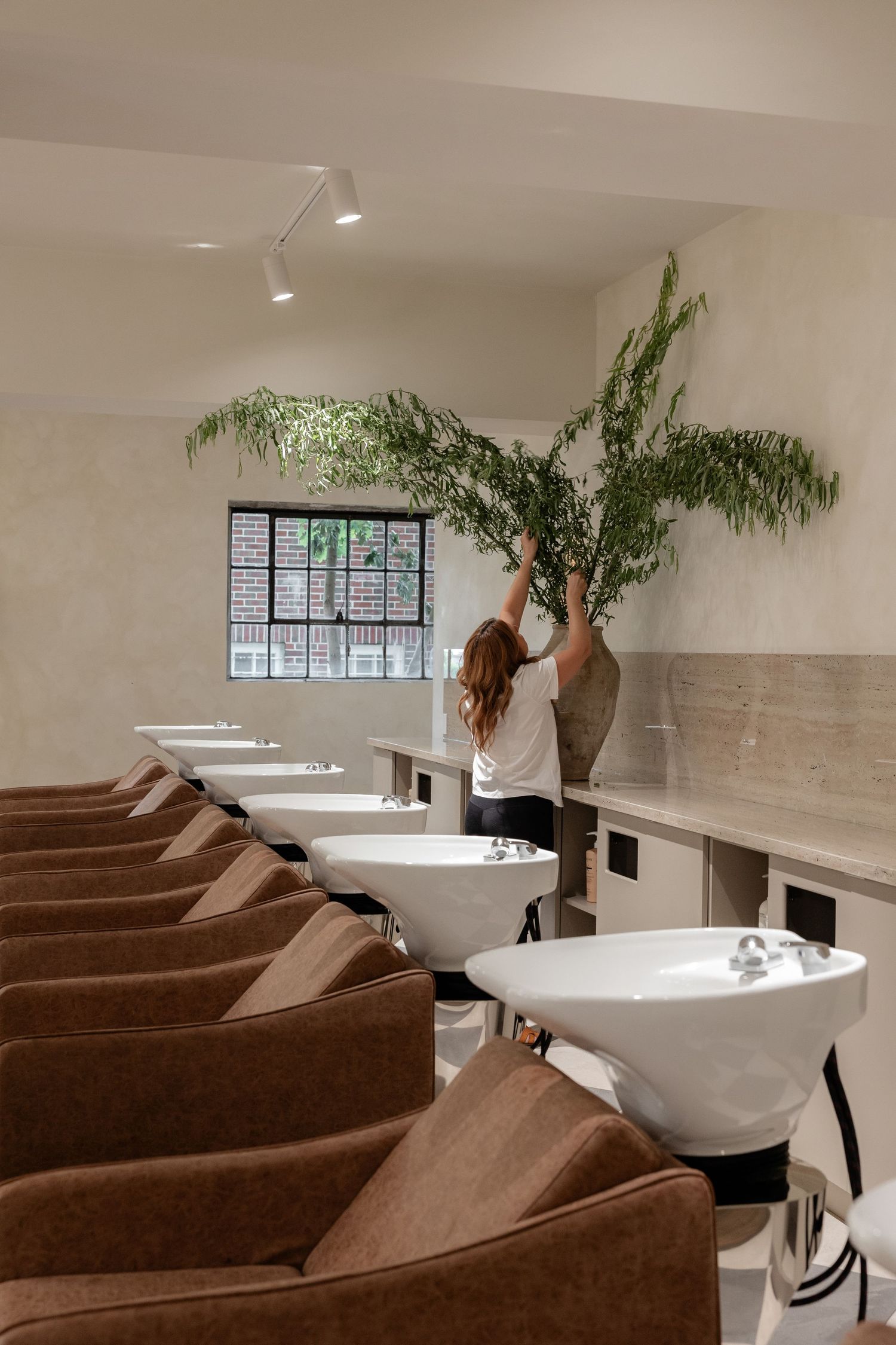 Spa room with row of luxurious brown chairs and freestanding bathtubs.
