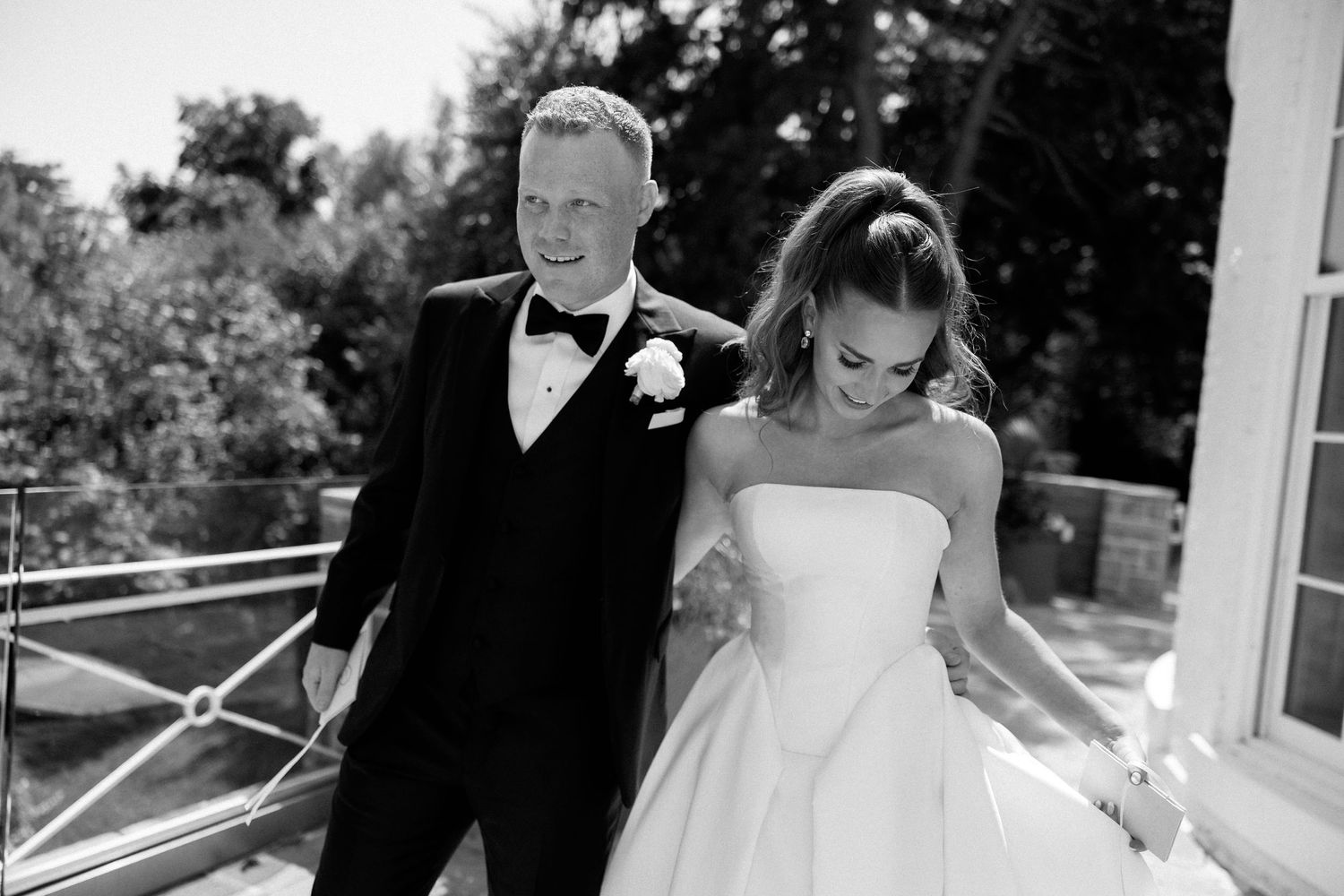 Candid black and white moment of newlyweds walking together on their wedding day.