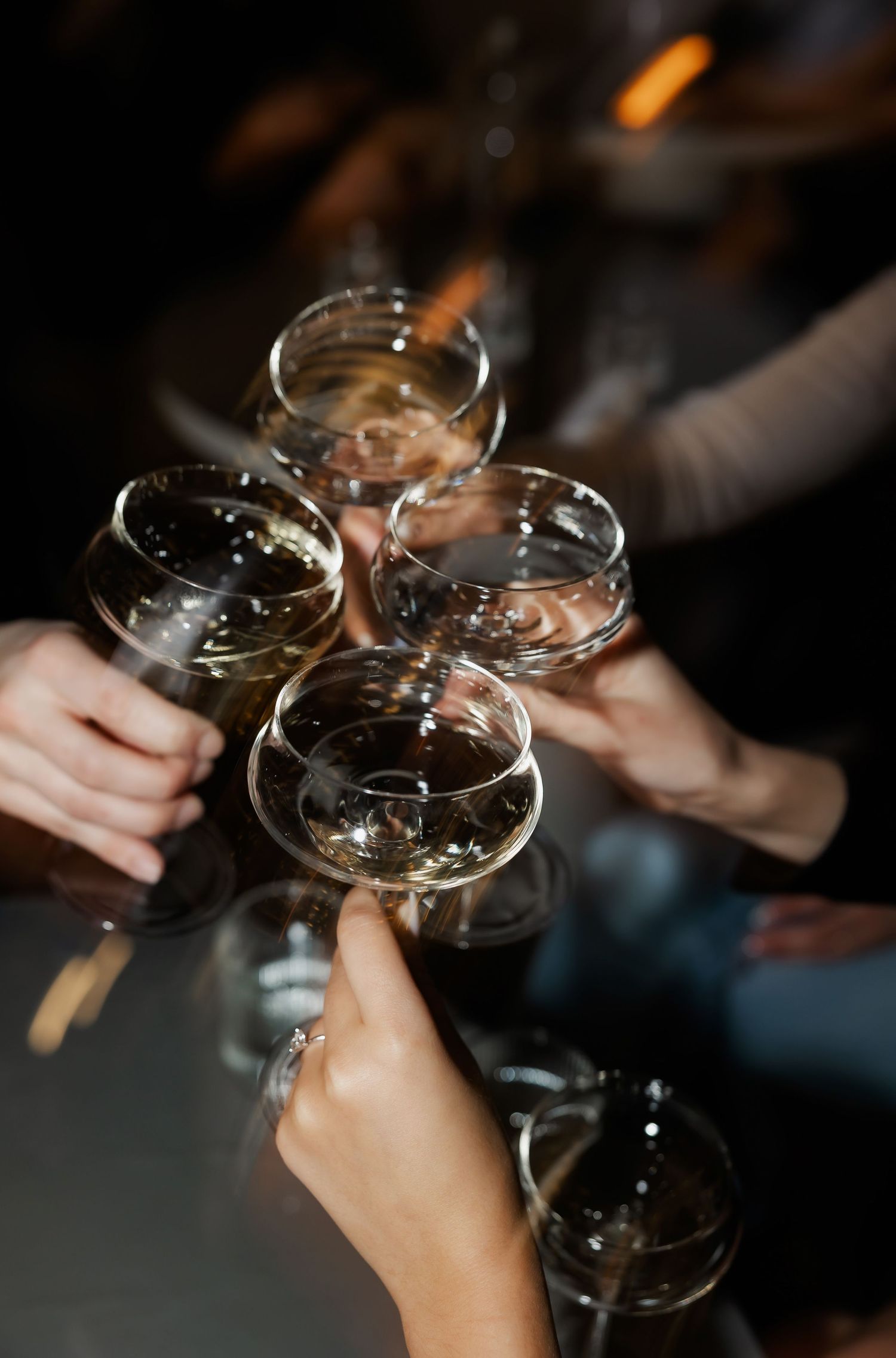 Friends toasting with champagne glasses in a dimly lit setting during a celebration.