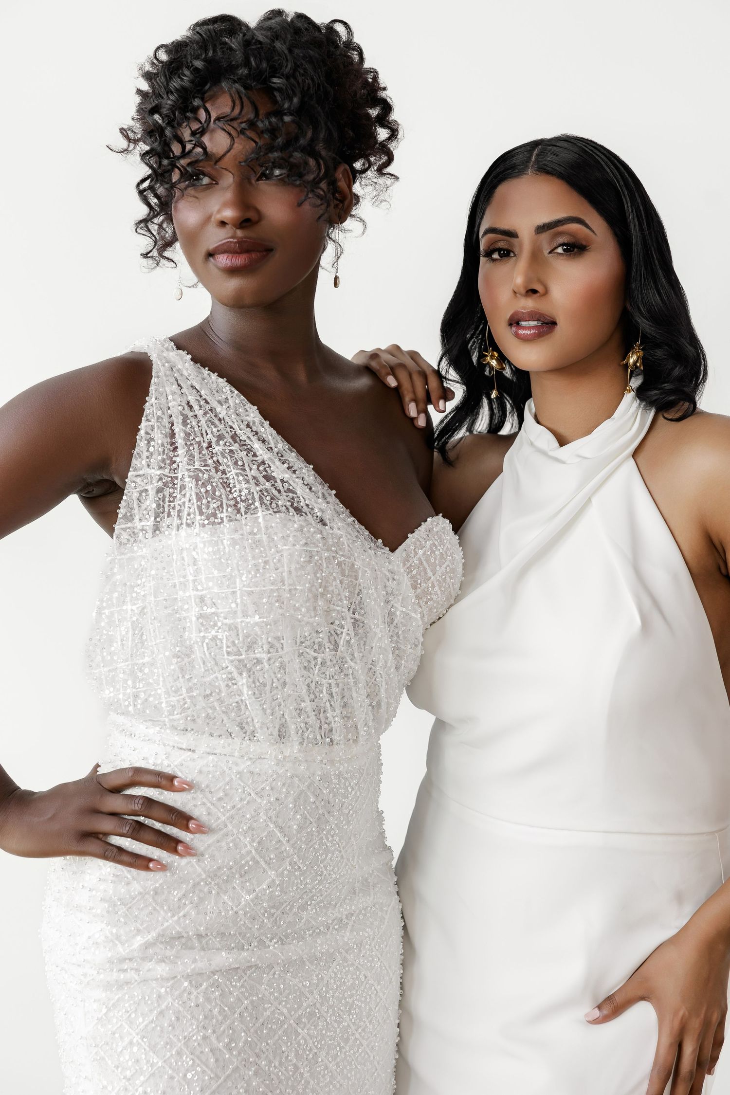 Models showcase contrasting wedding dresses, one in sparkly beaded detail and one in sleek modern design.