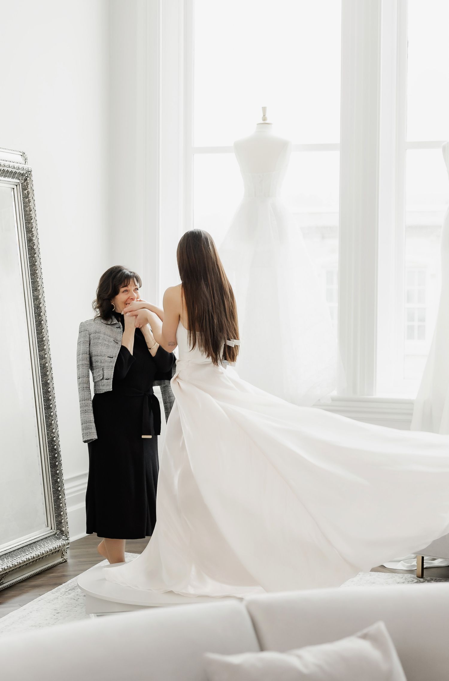 Wedding dress consultation with flowing white gown in a bright modern boutique.