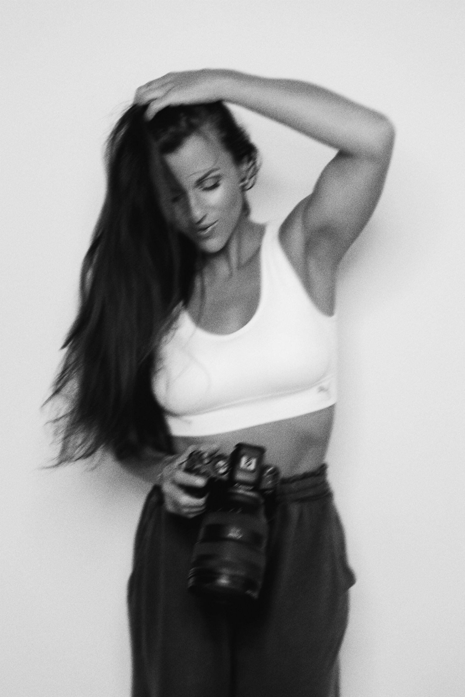 Black and white portrait of photographer with camera in casual attire.