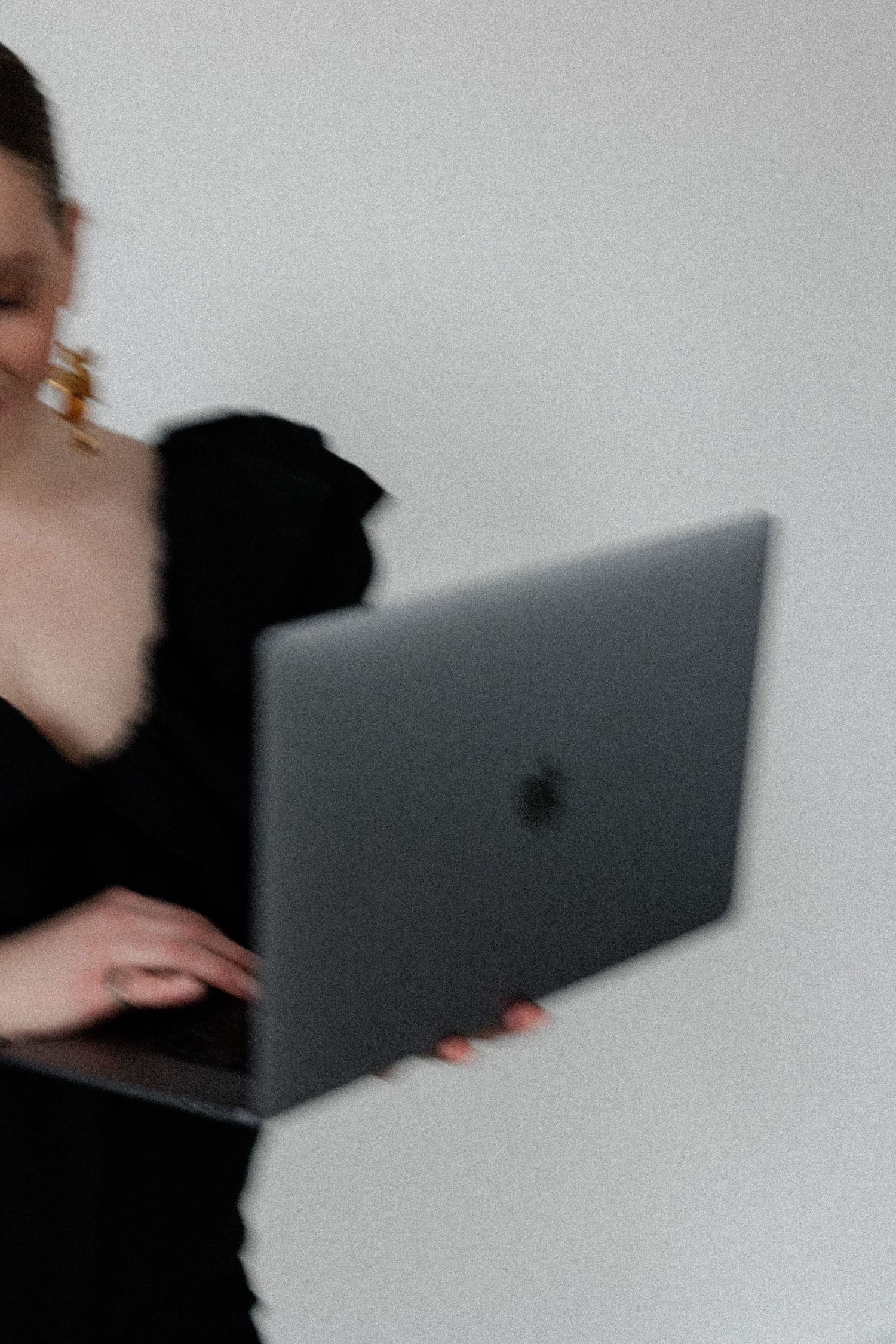 Motion blur portrait with MacBook laptop in black evening wear.
