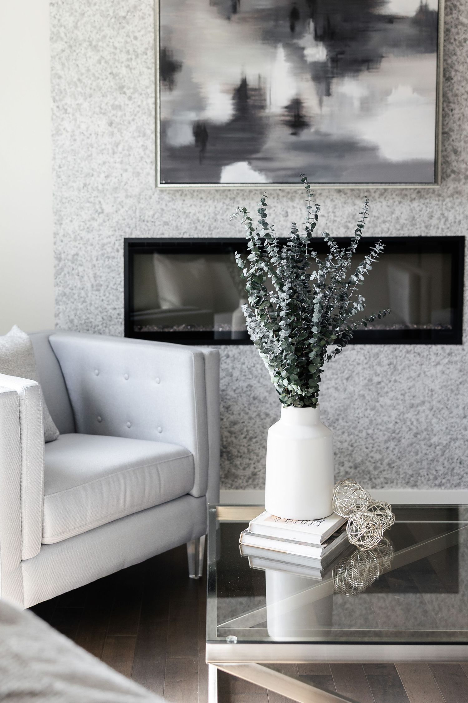 Modern living room features black and white artwork above a white sofa with green plant decor.
