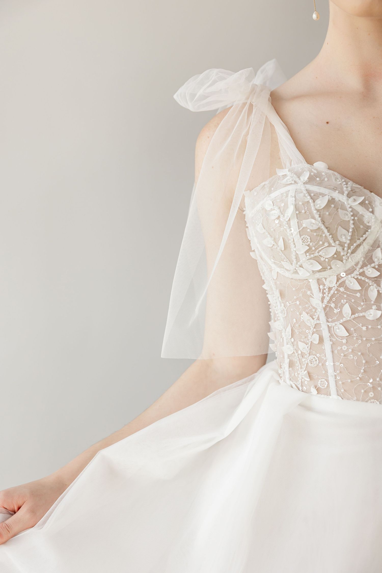 Close-up of intricate lace bodice details on white wedding gown.