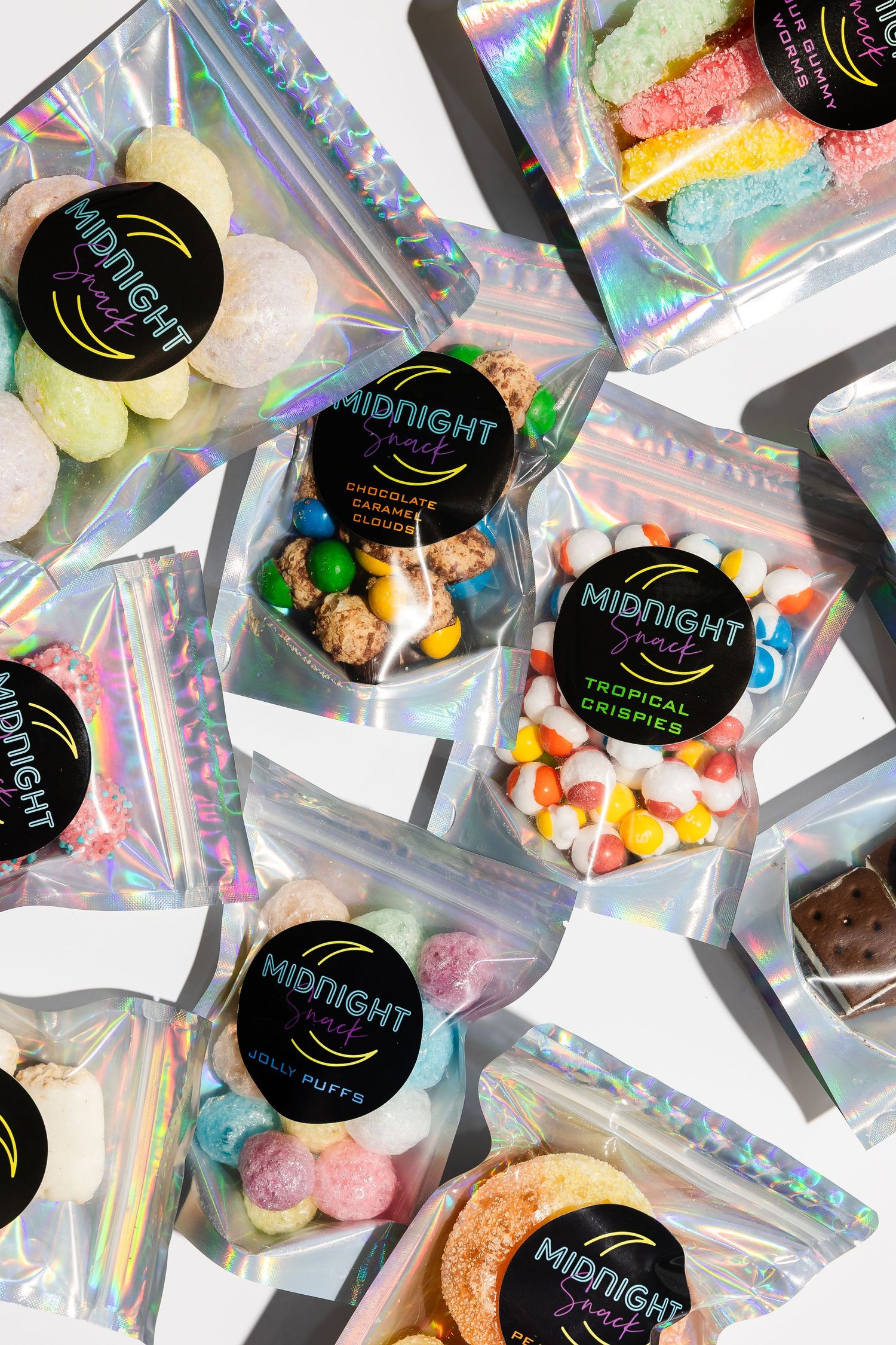 Multiple holographic snack packages with Midnight branding displayed in grid pattern.