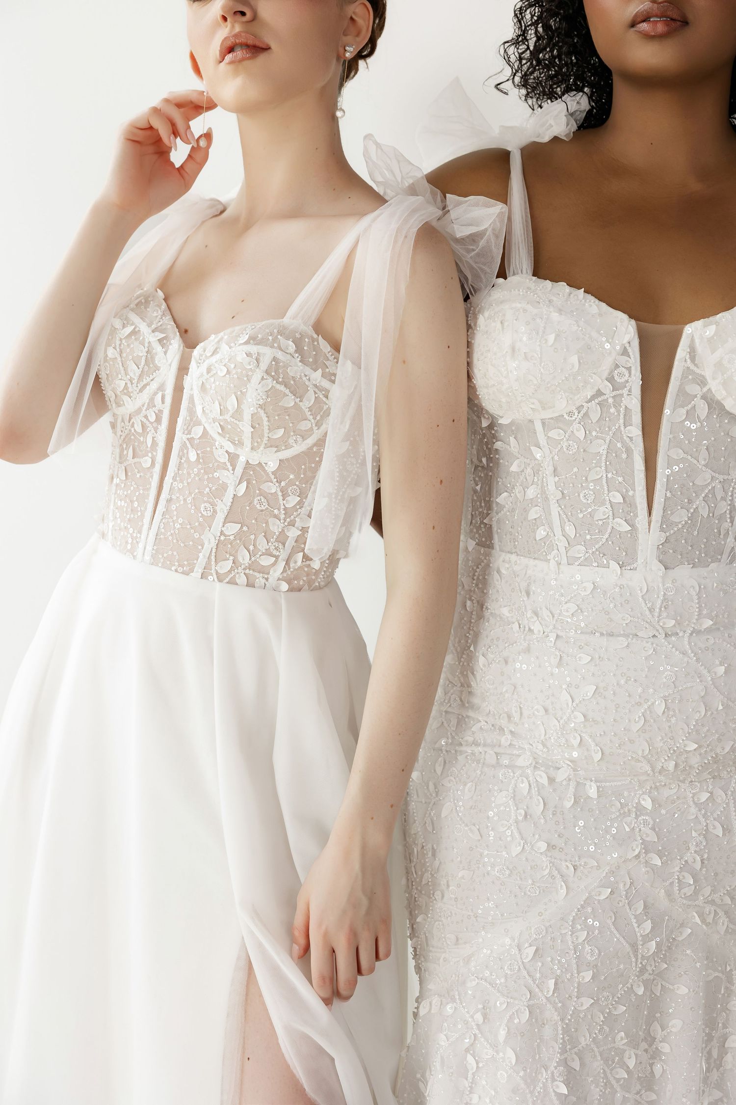 Close-up view of wedding dress bodices featuring delicate lace and sheer details.